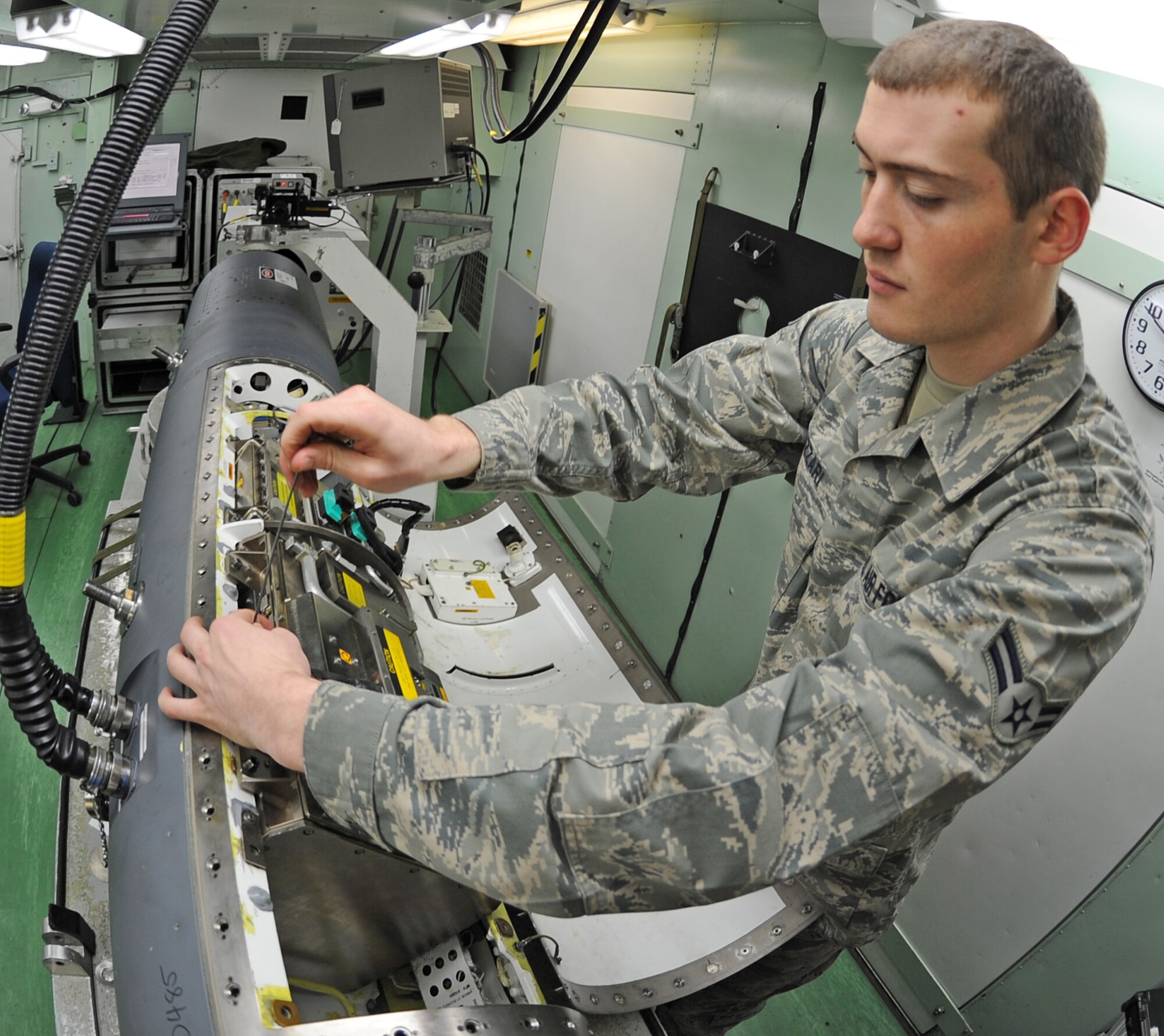 U.S. Air Force Airman 1st Class Thacher Lazzari, 4th Component Maintenance Squadron avionics sensors specialist, installs a new power supply on an F-15E Strike Eagle target pod on Seymour Johnson Air Force, N.C., Jan. 8, 2013. The Strike Eagle target pods enable aircrew with the ability to guide ordnance to air and ground targets. (U.S. Air Force photo/Airman 1st Class Gino Reyes/Released)