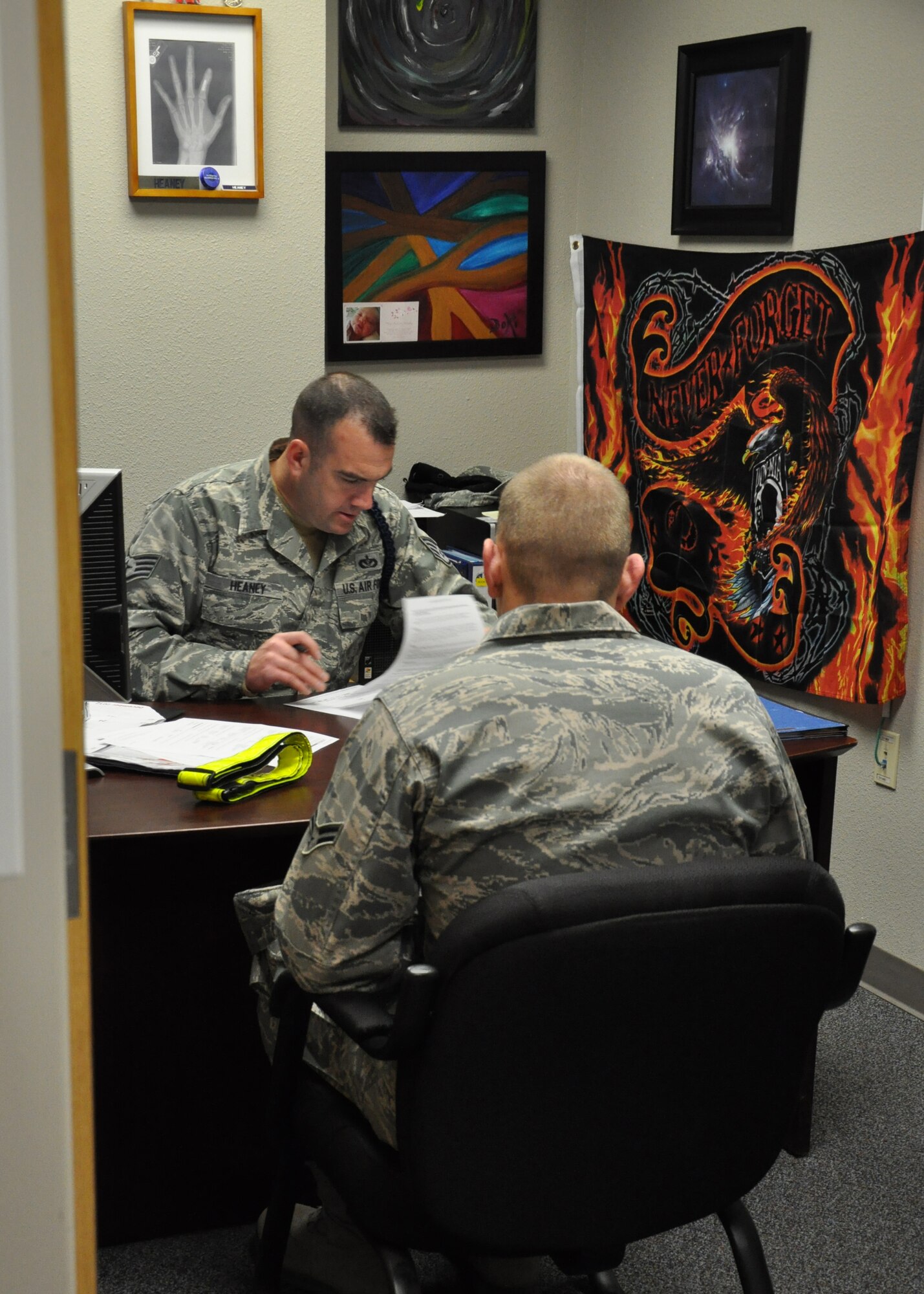 GOODFELLOW AIR FORCE BASE, Texas - Staff Sgt. Barak Heaney, 316th Training Squadron military training instructor, reviews Airman 1st Class Michael Litherland's, 316th Training Squadron student, final out processing checklist in Heaney’s office at Building 3139 here, Dec. 20. This is one of the last steps Litherland needed to complete before moving on to his next duty station. (U.S. Air Force photo/ Airman 1st Class Joshua Edwards)