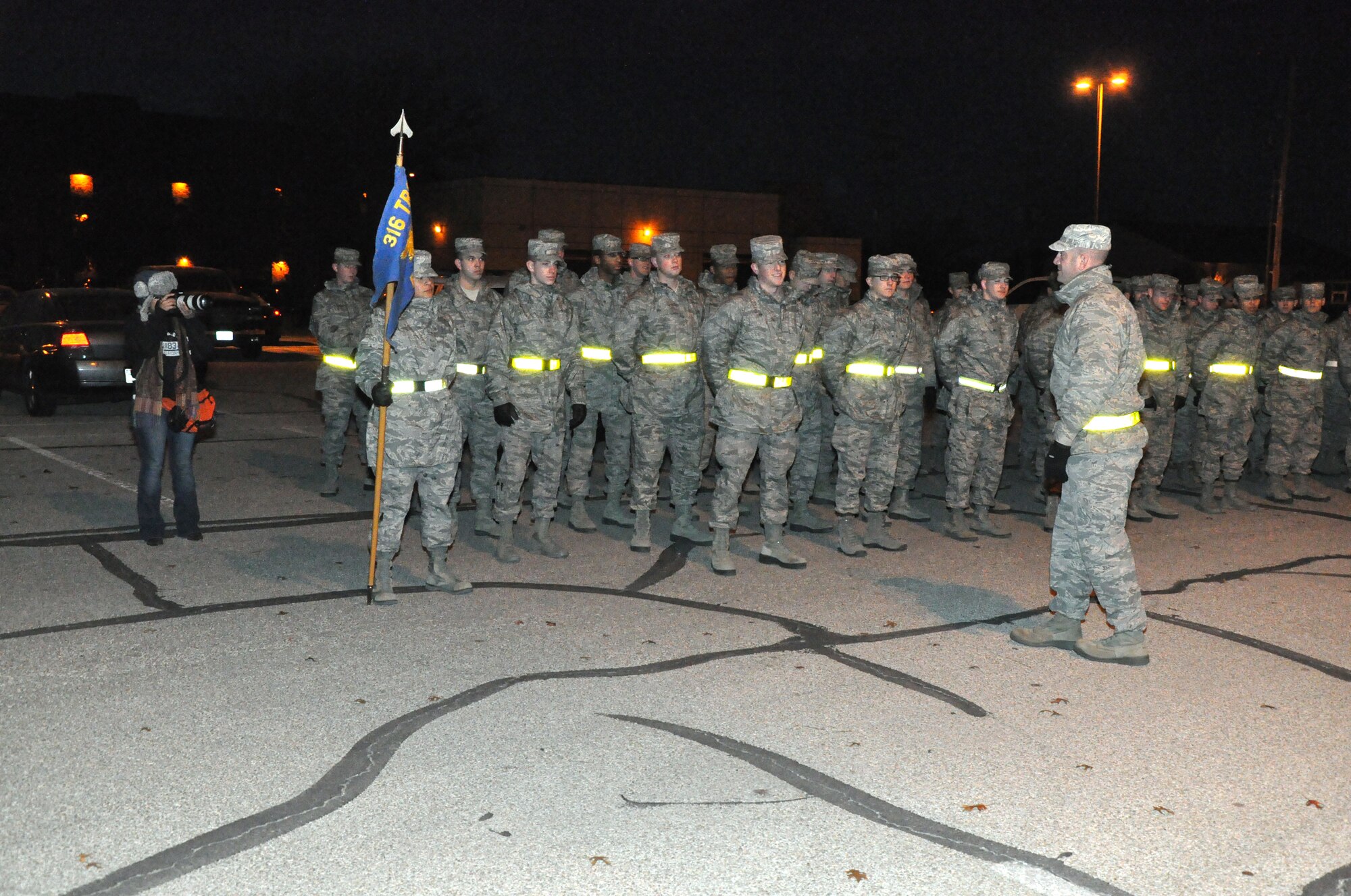 GOODFELLOW AIR FORCE BASE, Texas - Staff Sgt. Barak Heaney, 316th Training Squadron military training instructor, addresses 316th Training Squadron students while Jennifer Rios, The Standard-Times journalist, takes photos of him near the Western Winds dining facility here, Dec. 20. Barak reminded the Airmen that all the food needed to be removed from their refrigerators and all electronics needed to be unplugged, before they left for the Annual Exodus. (U.S. Air Force photo/ Airman 1st Class Joshua Edwards)