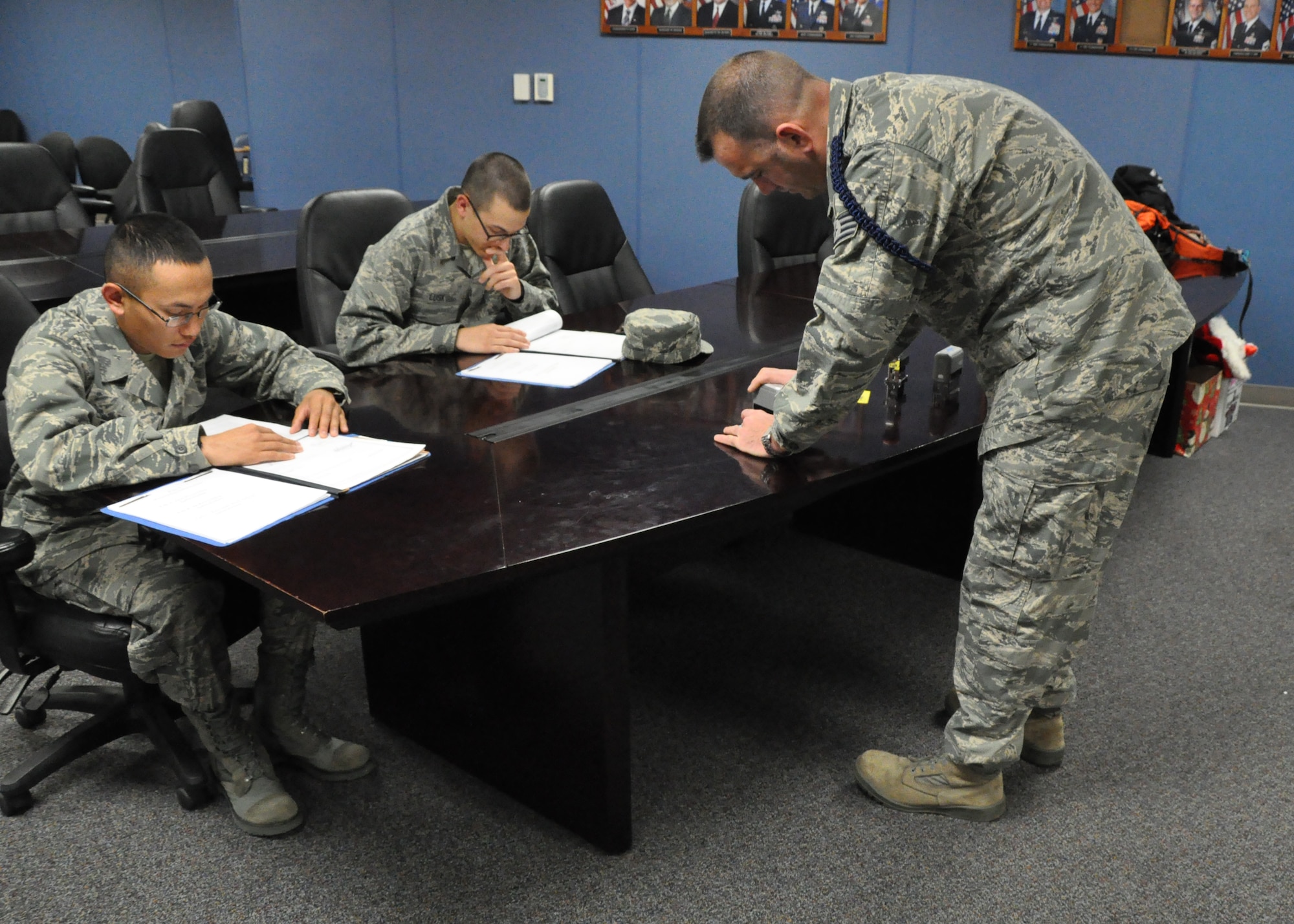 GOODFELLOW AIR FORCE BASE, Texas – Staff Sgt. Barak Heaney, 316th Training Squadron military training instructor, stamps Airman Marvic Bodie’s, 316th Training Squadron student, and Airman Caleb Lusk’s, 316th Training Squadron student, Advance Transition Phase Card in Building 3139 here, Dec. 20. This was the first part of Heaney’s day that Jennifer Rios, Standard-Times journalist, saw as she shadowed him for a feature she was writing for The Standard-Times. (U.S. Air Force photo/ Airman 1st Class Joshua Edwards)