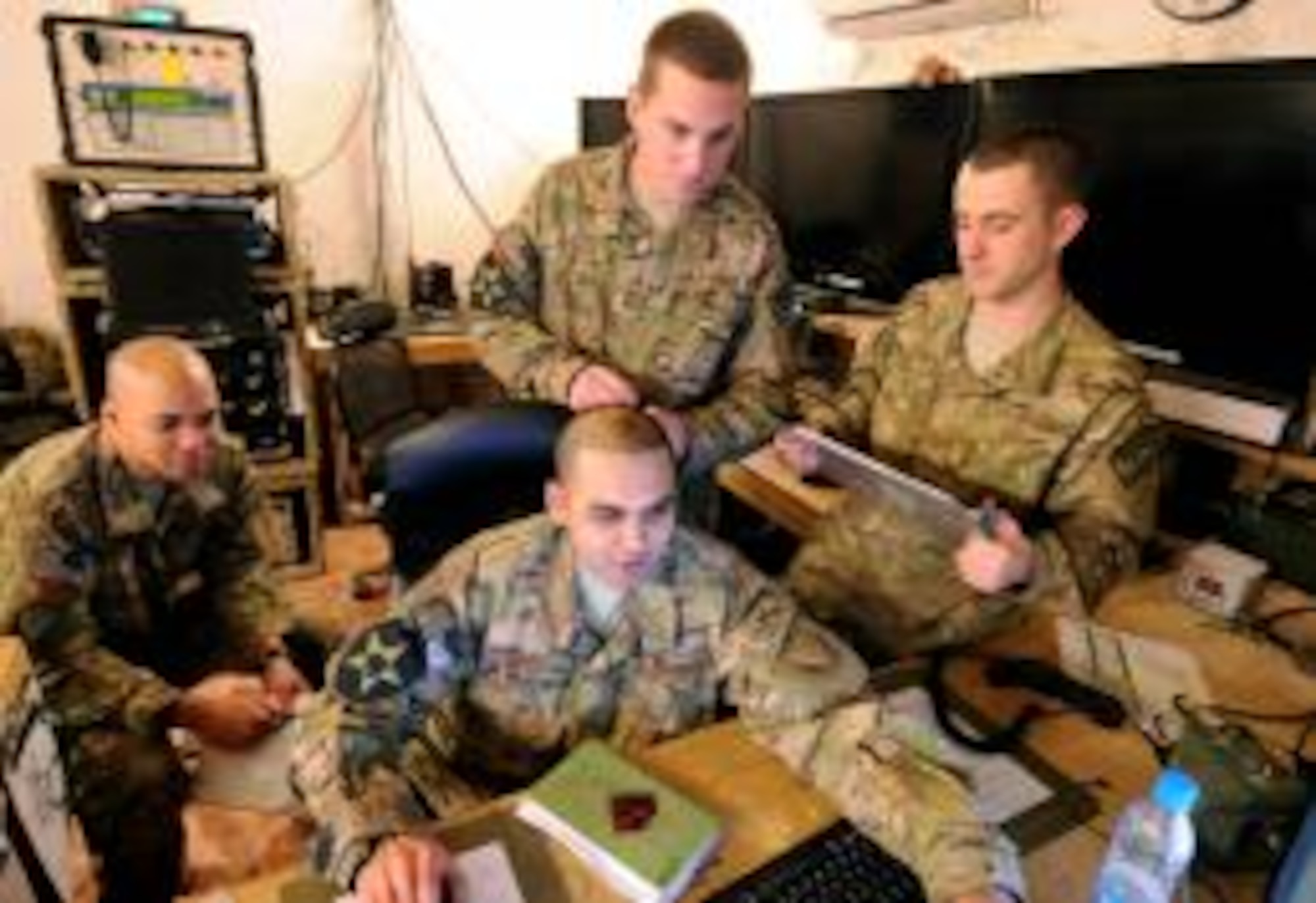 (From left) Senior Airmen Chase Rambo, Jasjit Singh, Corey Wiemers and Staff Sgt. Cameron Garrett, all members of the Zabul Provincial Reconstruction Team tactical operations center, perform a change over before switching shifts at Forward Operating Base Smart, Afghanistan, Jan. 1, 2013. All of the team members volunteered to deploy with the PRT and work outside their normal Air Force specialty. (U.S. Air Force Photo by Senior Airman Patrice Clarke)

