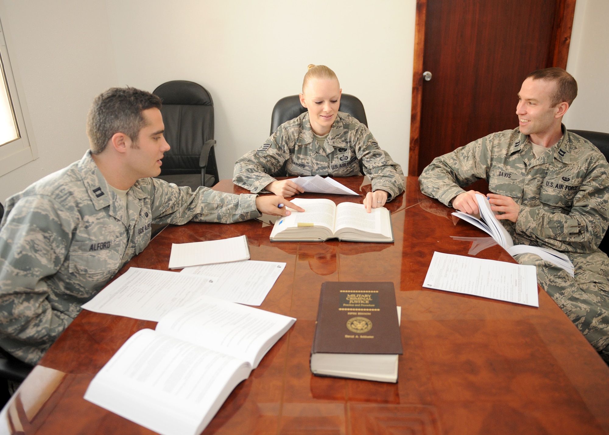 SOUTHWEST ASIA - From left, Capt. Tom Alford, Expeditionary Area Defense counsel, Staff Sgt. Jamie Garris, defense paralegal, and Capt. Jeff Davis, EADC, debate a constitutional issue in the EADC conference room. The EADC team, consisting of two attorneys and one defense paralegal, provides legal counsel to all Airmen facing adverse actions within the U.S. Air Forces Central Command's area of responsibility. (US Air Force photo/Senior Airman Joel Mease)