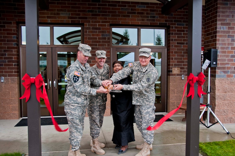 From left, Col. H. Charles Hodges, Joint Base Lewis-McChord commanders; Lt. COl. Jason Wing, Warrior Transition Battalion commander; Jacqueline Seabrook, Soldier and Family Assistance Center director; and Col. Dallas Homas, Madigan Healthcare System commander; cut the ribbon during the Installation Management Command's ceremony for the Soldier and Family Assistance Center and Open House for the Warrior Transistion Battalion Headquarters held Jan. 7 at Joint Base Lewis McChord.  The building was a U.S. Army Corps of Engineers, Seattle District, military construction project and was built by Doyon Government Group. 