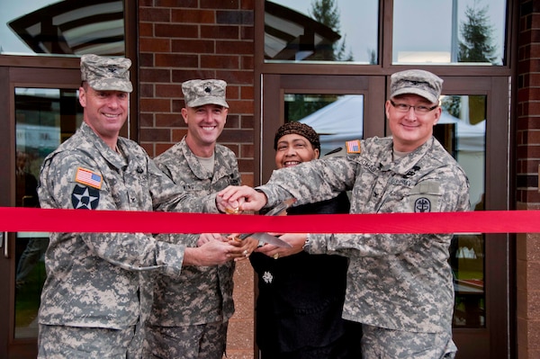 From left, Col. H. Charles Hodges, Joint Base Lewis-McChord commanders; Lt. COl. Jason Wing, Warrior Transition Battalion commander; Jacqueline Seabrook, Soldier and Family Assistance Center director; and Col. Dallas Homas, Madigan Healthcare System commander; cut the ribbon during the Installation Management Command's ceremony for the Soldier and Family Assistance Center and Open House for the Warrior Transistion Battalion Headquarters held Jan. 7 at Joint Base Lewis McChord.  The building was a U.S. Army Corps of Engineers, Seattle District, military construction project and was built by Doyon Government Group. 