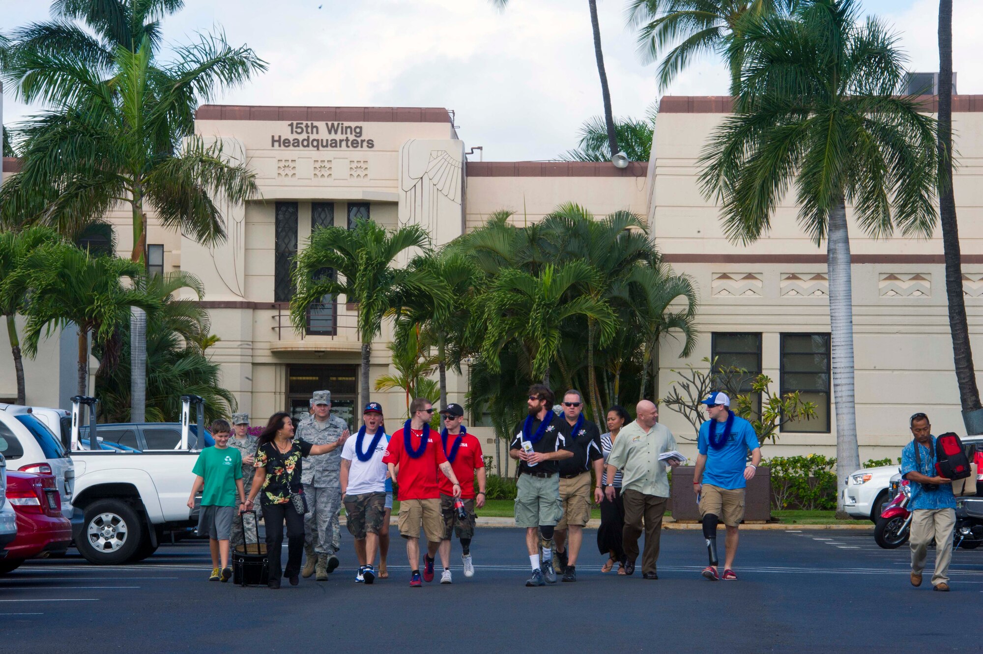 Members of the 15th Wing and the Wounded Warrior Amputee Softball team walk in front of the 15th Wing headquarters building Jan. 10 on Joint Base Pearl Harbor-Hickam, Hawaii. The WWAST mission is to raise awareness, through exhibition and celebrity softball games, of the sacrifices and resilience of the U.S. Military. (U.S. Air Force photo by Staff Sgt. Nathan Allen)