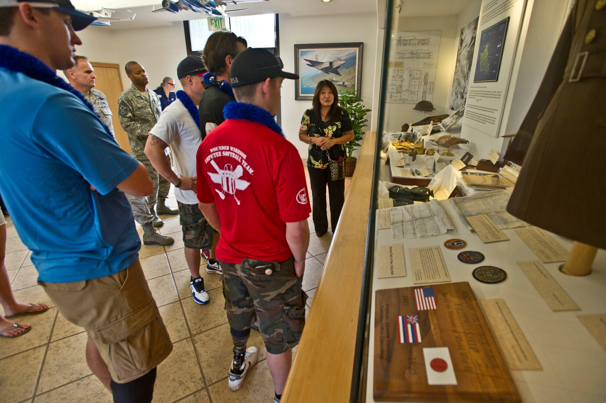 Ms. Jessie Higa, volunteer historian, tells the history of Hickam Field to members of the Wounded Warrior Amputee Softball team in the 15th Wing headquarters building Jan. 10 on Joint Base Pearl Harbor-Hickam, Hawaii. The WWAST mission is to raise awareness, through exhibition and celebrity softball games, of the sacrifices and resilience of the U.S. Military. (U.S. Air Force photo by Staff Sgt. Nathan Allen)