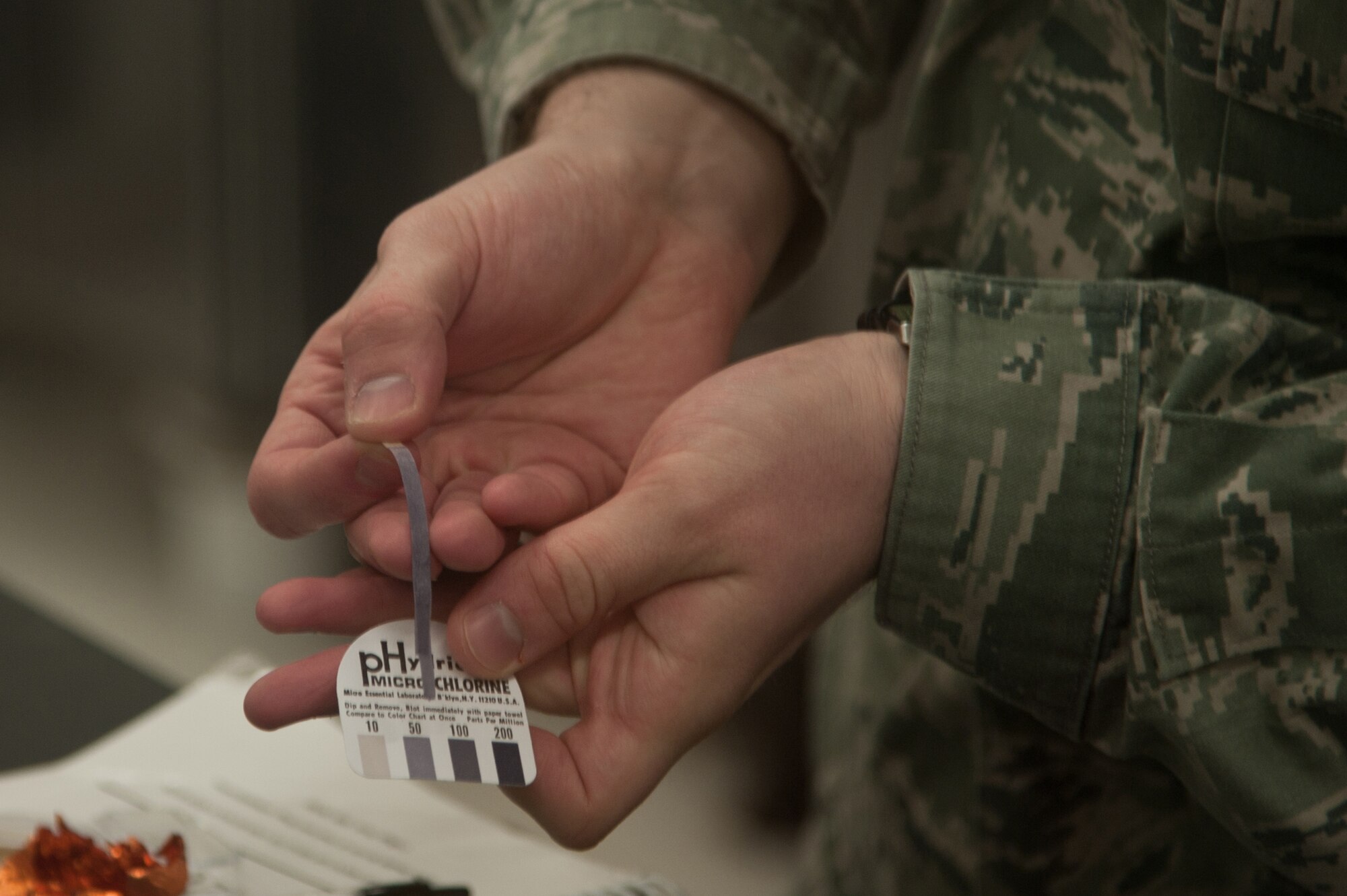 YOKOTA AIR BASE, Japan -- Staff Sgt. Nick Warner, 374th Aerospace Medicine Squadron NCO in charge of food inspection shop, displays a strip freshly dipped into a cleaning bucket at the Yokota Commissary Jan. 8, 2013. The proper amount of chlorine is anywhere between 50 and 100 micro levels. (U.S. Air Force photo by Senior Airman Cody H. Ramirez) 