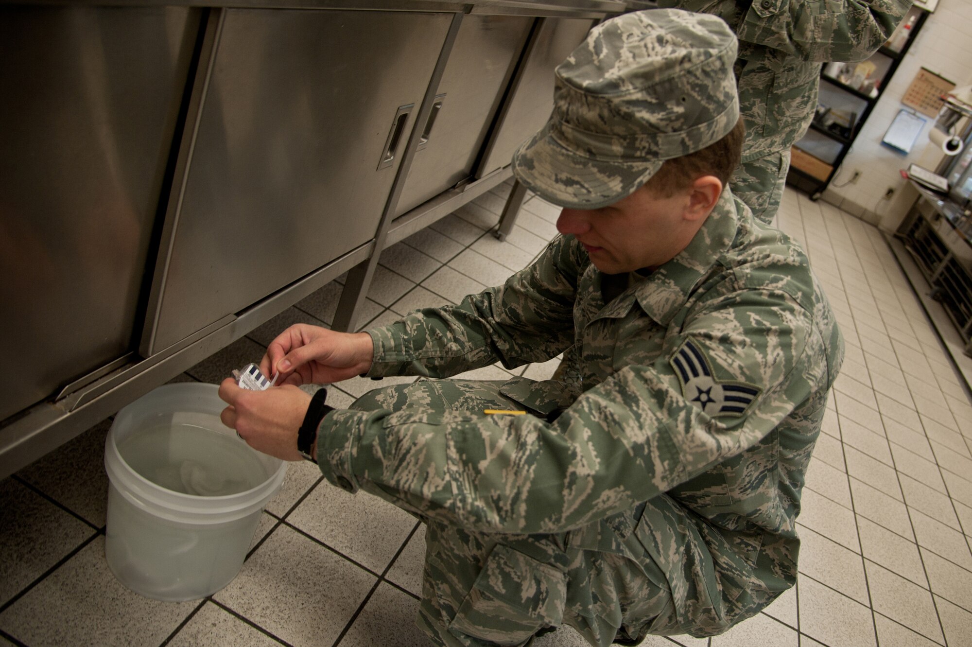 YOKOTA AIR BASE, Japan -- Senior Airman Roland Tyler, 374th Aerospace Medicine Squadron Public Health food and sanitation journeyman, checks the chlorine level of a cleaning bucket Jan. 8, 2013, during a facility health inspection. If cleaning solution does not have the proper amount of chlorine, then germs are spread rather than killed. (U.S. Air Force photo by Senior Airman Cody H. Ramirez)
