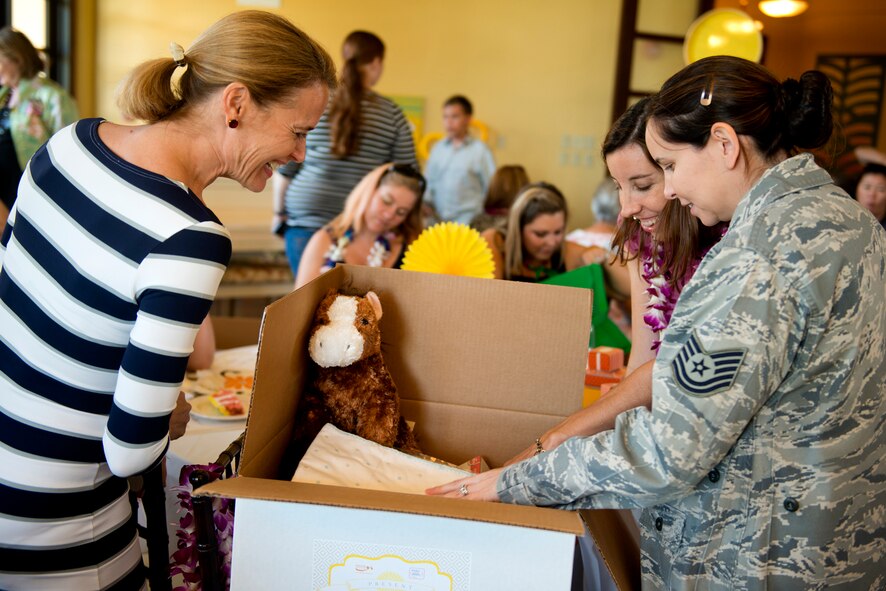Holly Finchem, wife of PGA Tour commissioner Tim Finchem, Tech Sgt. Dina Maldanado and Holly Terhune, both of 15th Operations Support Squadron, browse through the “Showers in a Box” during Operation Shower, “You Are My Sunshine,” Jan. 8 at the Ka Makani Community Center, Joint Base Pearl Harbor-Hickam, Hawaii. Terhune (purple lei) is the seven-month pregnant wife of Master Sgt. Jason Terhune, who is deployed to Afghanistan. The mothers and mothers-to-be being honored has their spouse already deployed or soon to be deployed. Each of the 40 mothers from multiple services on Hawaii received more than $1,000 worth of baby items ranging from gift cards, and diapers to crib bedding and strollers. This is the 28th baby shower held by the nonprofit group and the first in Hawaii. (U.S. Air Force photo/Staff Sgt. Mike Meares)