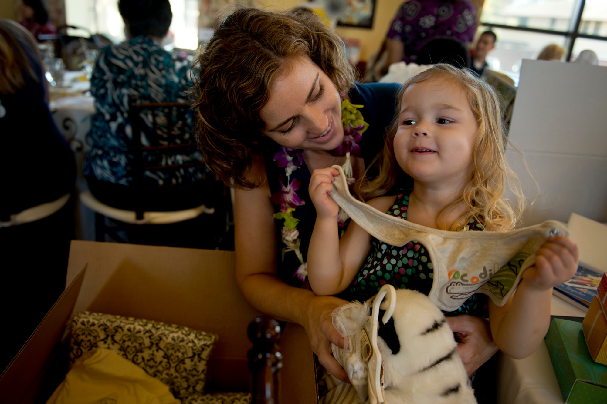 Danica Elliott, wife of a 25th Combat Aviation Brigade Soldier, Schofield Barracks, Hawaii, and daughter Idra, 2, looks at items they picked out of the “Showers in a Box” during Operation Shower, "You Are My Sunshine," Jan. 8 at the Ka Makani Community Center, Joint Base Pearl Harbor-Hickam, Hawaii. The mothers and mothers-to-be being honored has their spouse already deployed or soon to be deployed. Each of the 40 mothers from multiple services on Hawaii received more than $1,000 worth of baby items ranging from gift cards, and diapers to crib bedding and strollers. This is the 28th baby shower held by the nonprofit group and the first in Hawaii.   (U.S. Air Force photo/Staff Sgt. Mike Meares)