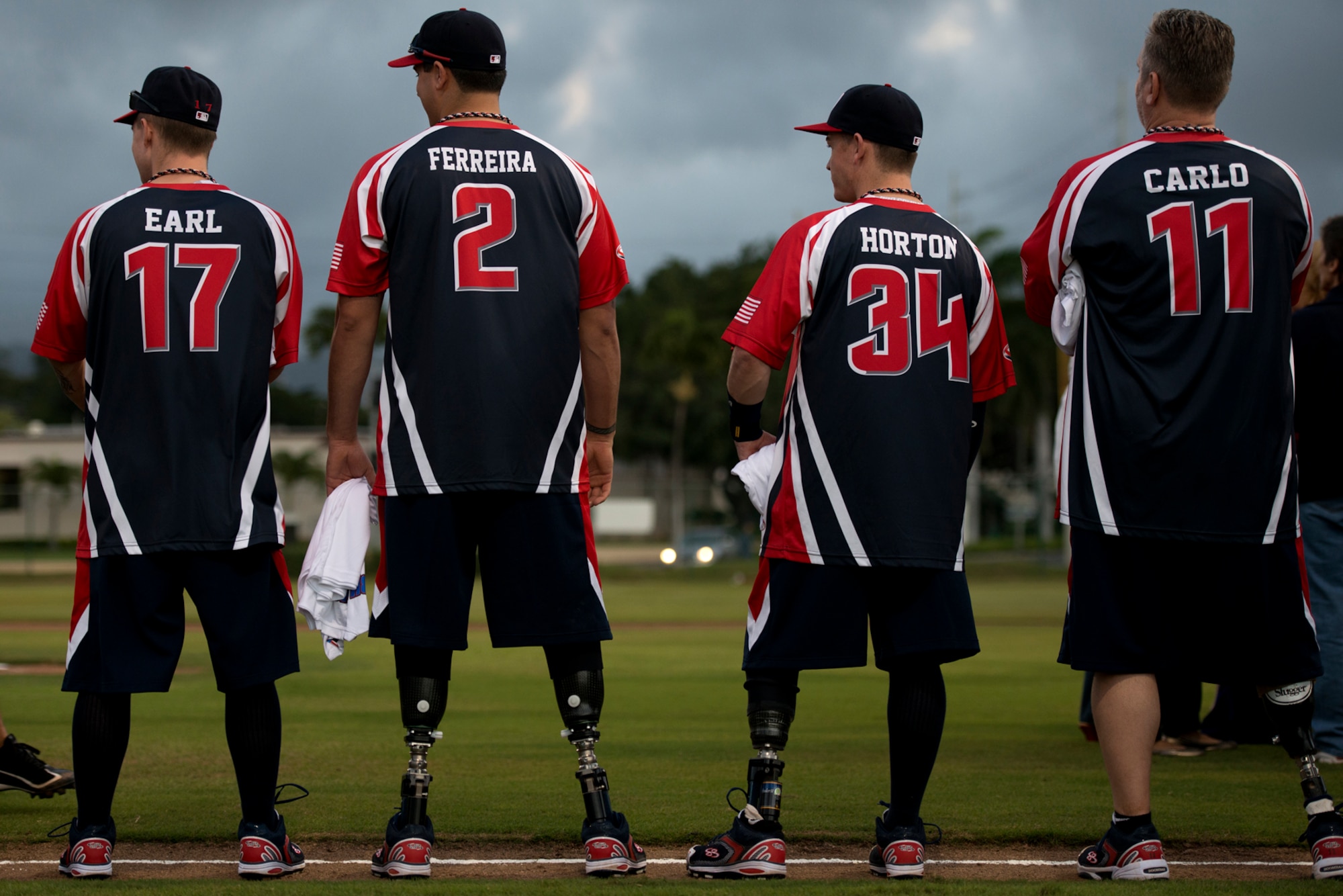 Members of the Wounded Warrior Amputee Softball Team greet members of the Hickam Force and Hickam Chiefs during player introductions at the beginning of a double header Jan. 8, 2013, at Milican Field, Joint Base Pearl Harbor-Hickam, Hawaii. Hickam Force won the first game 18-1, but the Warriors held off the Chiefs Group to win 22-17. The WWAST is comprised of competitive, athletic veterans and active duty servicemembers who have lost limbs during post-9/11 combat operations. The team includes individuals with a variety of amputations of the arm, above knee, below knee, bilateral below knee, and foot. Some are still in the service, while others are attending college thanks to the Post-9/11 GI Bill while others have moved on to new careers. (U.S. Air Force photo/Staff Sgt. Mike Meares)
