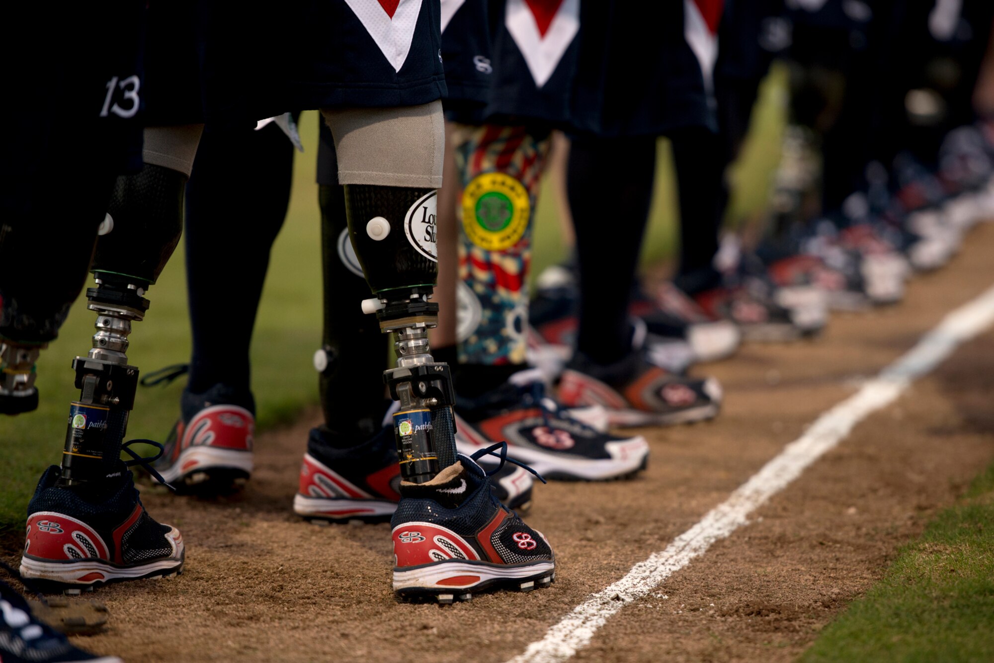 Members of the Wounded Warrior Amputee Softball Team greet members of the Hickam Force and Hickam Chiefs during player introductions at the beginning of a double header Jan. 8, 2013, at Milican Field, Joint Base Pearl Harbor-Hickam, Hawaii. Hickam Force won the first game 18-1, but the Warriors held off the Chiefs Group to win 22-17. The WWAST is comprised of competitive, athletic veterans and active duty servicemembers who have lost limbs during post-9/11 combat operations. The team includes individuals with a variety of amputations of the arm, above knee, below knee, bilateral below knee, and foot. Some are still in the service, while others are attending college thanks to the Post-9/11 GI Bill while others have moved on to new careers. (U.S. Air Force photo/Staff Sgt. Mike Meares)