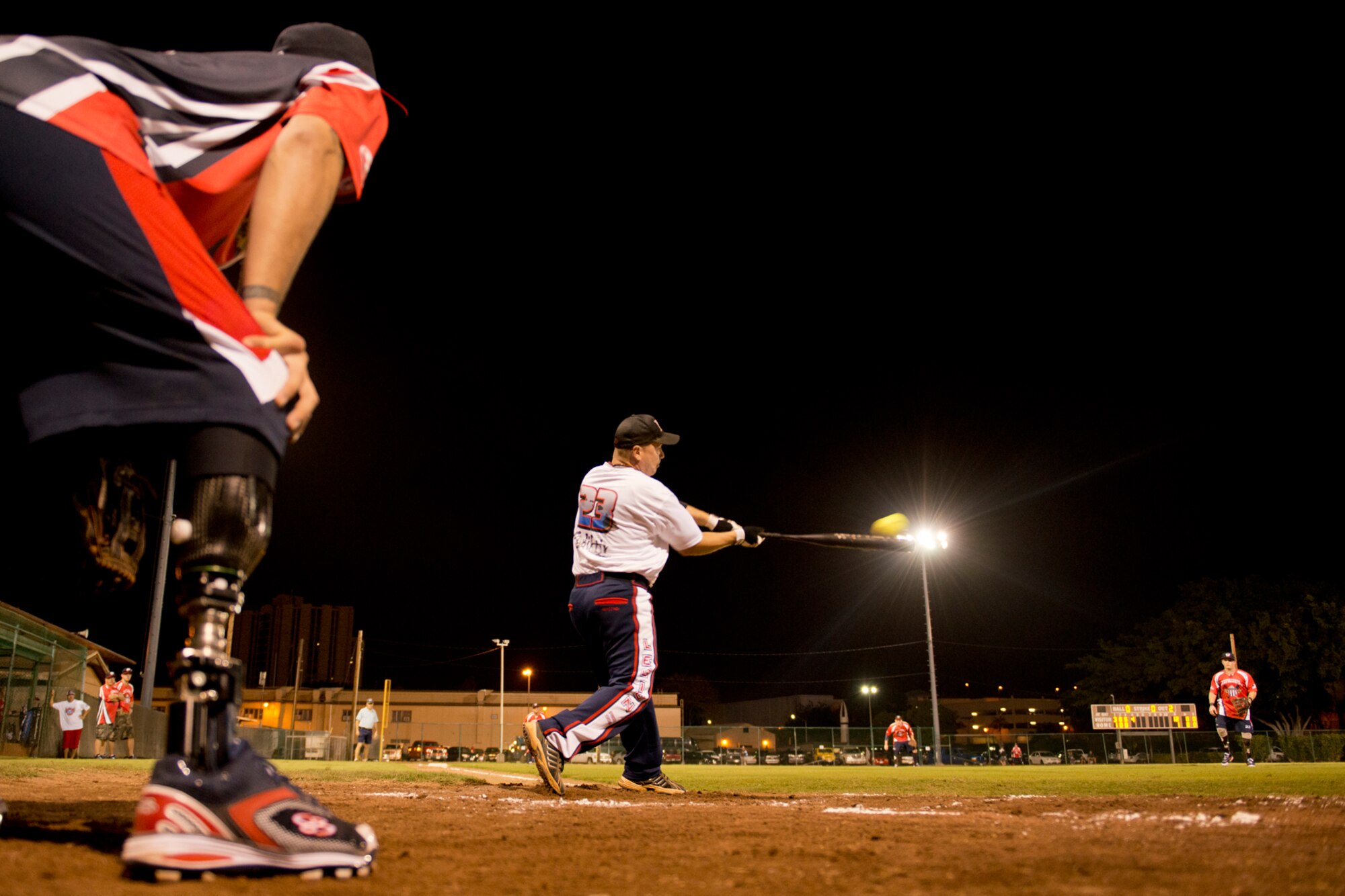Tony Karpenko, Hickam Force, drives a ball into center field during a game against Wounded Warrior Amputee Softball Team Jan. 8, 2013, at Milican Field, Joint Base Pearl Harbor-Hickam, Hawaii. Hickam Force won the first game 18-1, but the Warriors held off the Chiefs Group to win 22-17. Karpenko is a master sergeant with the 647th Logistics Readiness Squadron fuels flight. The WWAST is comprised of competitive, athletic veterans and active duty servicemembers who have lost limbs during post-9/11 combat operations. The team includes individuals with a variety of amputations of the arm, above knee, below knee, bilateral below knee, and foot. Some are still in the service, while others are attending college thanks to the Post-9/11 GI Bill while others have moved on to new careers. (U.S. Air Force photo/Staff Sgt. Mike Meares)