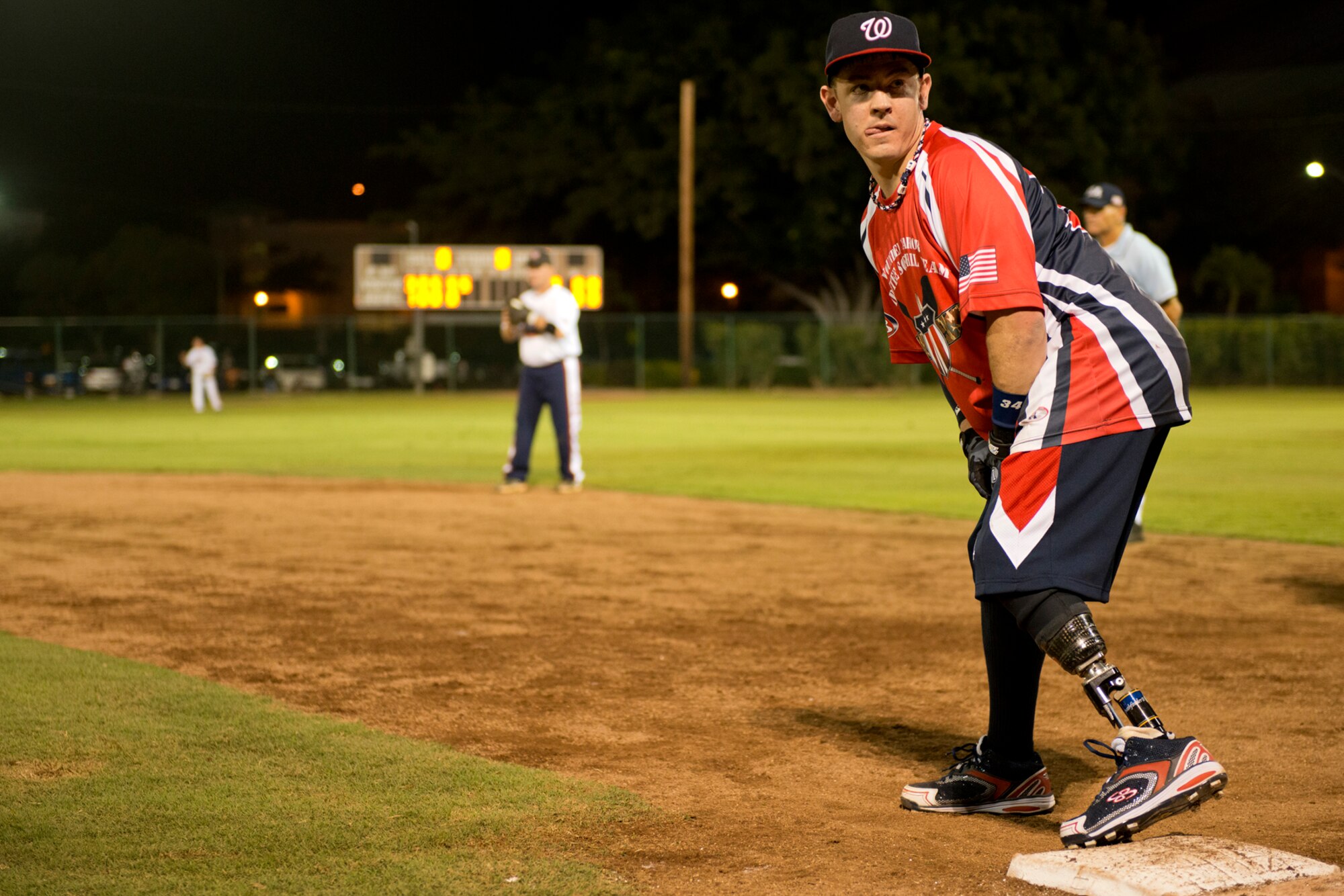 Tim Horton, Wounded Warrior Amputee Softball Team, gets instruction from the first base coach during a game against Hickam Force, Jan. 8, 2013, at Milican Field, Joint Base Pearl Harbor-Hickam, Hawaii. Hickam Force won the first game 18-1, but the Warriors held off the Chiefs Group to win 22-17. The WWAST is comprised of competitive, athletic veterans and active duty servicemembers who have lost limbs during post-9/11 combat operations. The team includes individuals with a variety of amputations of the arm, above knee, below knee, bilateral below knee, and foot. Some are still in the service, while others are attending college thanks to the Post-9/11 GI Bill while others have moved on to new careers. (U.S. Air Force photo/Staff Sgt. Mike Meares)