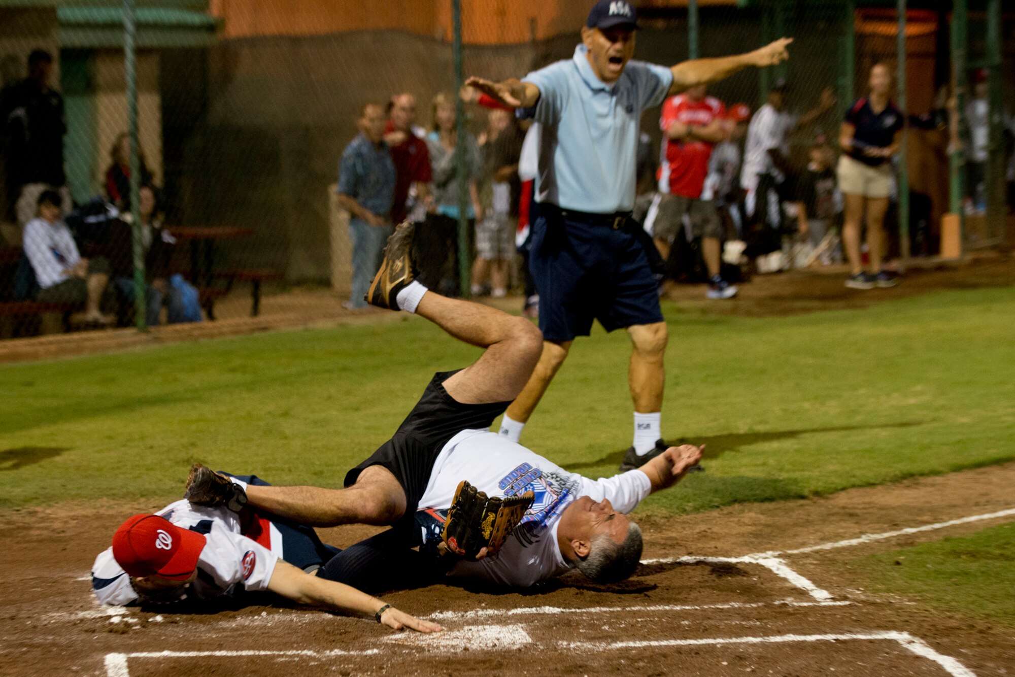 Kyle Earl, Wounded Warrior Amputee Softball Team, slides in safely at home, taking out Chuck Willis, Pacific Air Forces, Chiefs Group, Jan. 8, 2013, at Milican Field, Joint Base Pearl Harbor-Hickam, Hawaii. Hickam Force won the first game 18-1, but the Warriors held off the Chiefs Group to win 22-17. Earl is A U.S. Marine who lost his right hand during Operation Iraqi Freedom. The WWAST is comprised of competitive, athletic veterans and active duty servicemembers who have lost limbs during post-9/11 combat operations. The team includes individuals with a variety of amputations of the arm, above knee, below knee, bilateral below knee, and foot. Some are still in the service, while others are attending college thanks to the Post-9/11 GI Bill while others have moved on to new careers. (U.S. Air Force photo/Staff Sgt. Mike Meares)