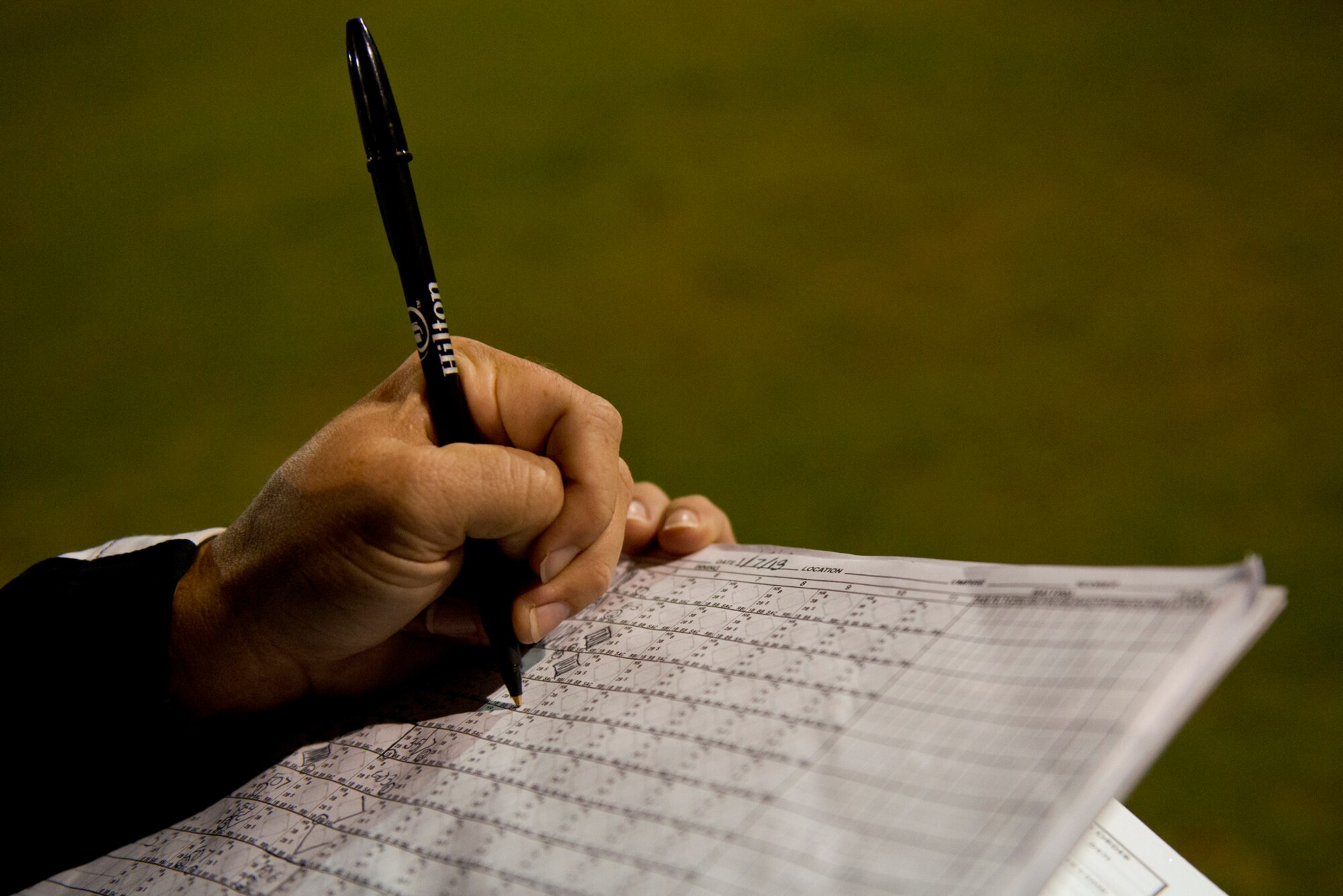 An assistant keeps score of the double-header softball game between the Wounded Warrior Amputee Softball Team and Hickam Airmen Jan. 8, 2013, at Milican Field, Joint Base Pearl Harbor-Hickam, Hawaii. An accurate scorecard helps the Warriors track their statistics throughout the season. The WWAST is comprised of competitive, athletic veterans and active duty servicemembers who have lost limbs during post-9/11 combat operations. The team includes individuals with a variety of amputations of the arm, above knee, below knee, bilateral below knee, and foot. Some are still in the service, while others are attending college thanks to the Post-9/11 GI Bill while others have moved on to new careers. (U.S. Air Force photo/Staff Sgt. Mike Meares)
