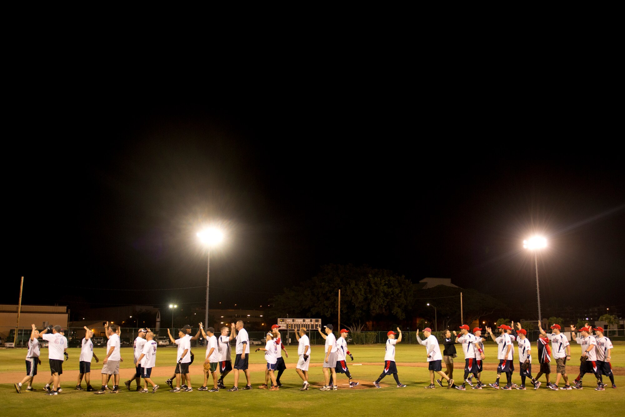 The Wounded Warrior Amputee Softball Team and the Hickam Chiefs Group show a sign of sportsmanship to culminate a double header against Hickam Airmen Jan. 8, 2013, at Milican Field, Joint Base Pearl Harbor-Hickam, Hawaii. Hickam Force won the first game 18-1, but the Warriors held off the Chief’s Group to win 22-17. The WWAST is comprised of competitive, athletic veterans and active duty servicemembers who have lost limbs during post-9/11 combat operations. The team includes individuals with a variety of amputations of the arm, above knee, below knee, bilateral below knee, and foot. Some are still in the service, while others are attending college thanks to the Post-9/11 GI Bill while others have moved on to new careers. (U.S. Air Force photo/Staff Sgt. Mike Meares)