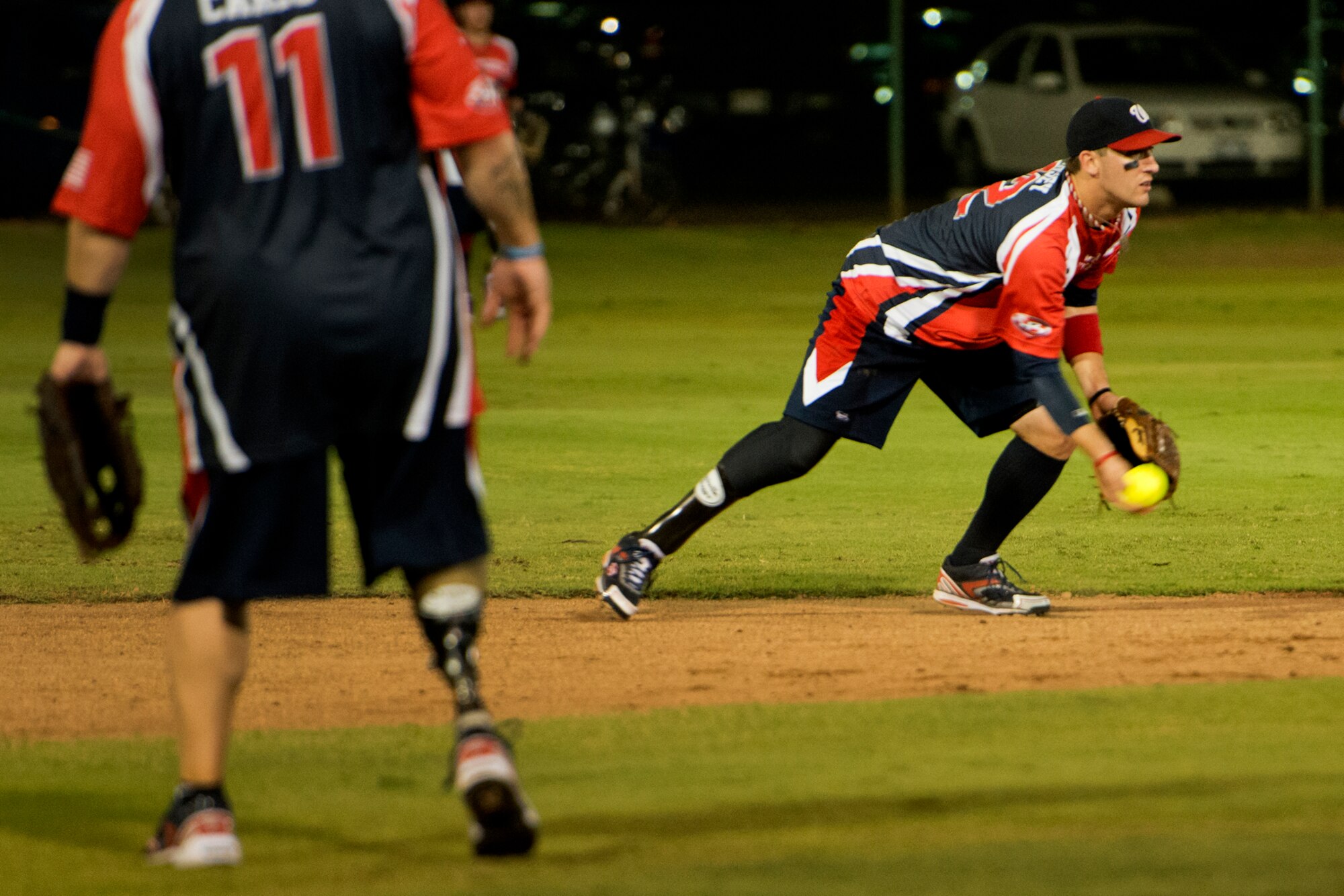 Matt Kinsey, Wounded Warrior Amputee Softball Team, tosses a connects with a pitch during the first inning of play against the Hickam Force Jan. 8, 2013, at Milican Field, Joint Base Pearl Harbor-Hickam, Hawaii. Hickam Force won the first game 18-1, but the Warriors held off the Chiefs Group to win 22-17. The WWAST is comprised of competitive, athletic veterans and active duty servicemembers who have lost limbs during post-9/11 combat operations. The team includes individuals with a variety of amputations of the arm, above knee, below knee, bilateral below knee, and foot. Some are still in the service, while others are attending college thanks to the Post-9/11 GI Bill while others have moved on to new careers. (U.S. Air Force photo/Staff Sgt. Mike Meares)