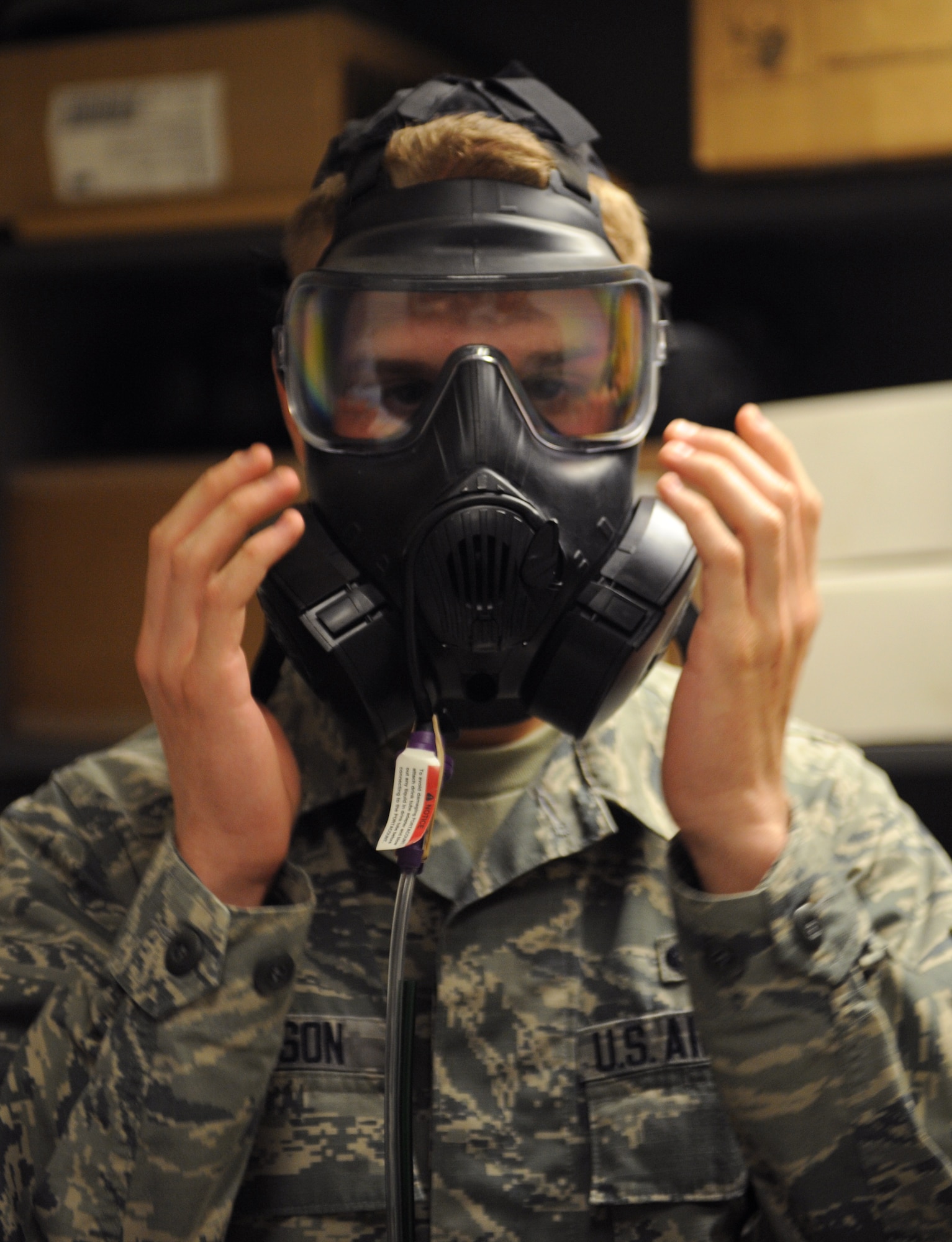 Airman 1st Class Brandon Johnson, 608th Air Operations Center operations intelligence analyst, checks the seal on an M-50 gas mask on Barksdale Air Force Base, La., Jan. 10. Barksdale personnel perform a number of breathing exercises to ensure they have the correct gas mask size and that there is no break in the seal. (U.S. Air Force photo/Airman 1st Class Benjamin Gonsier)
