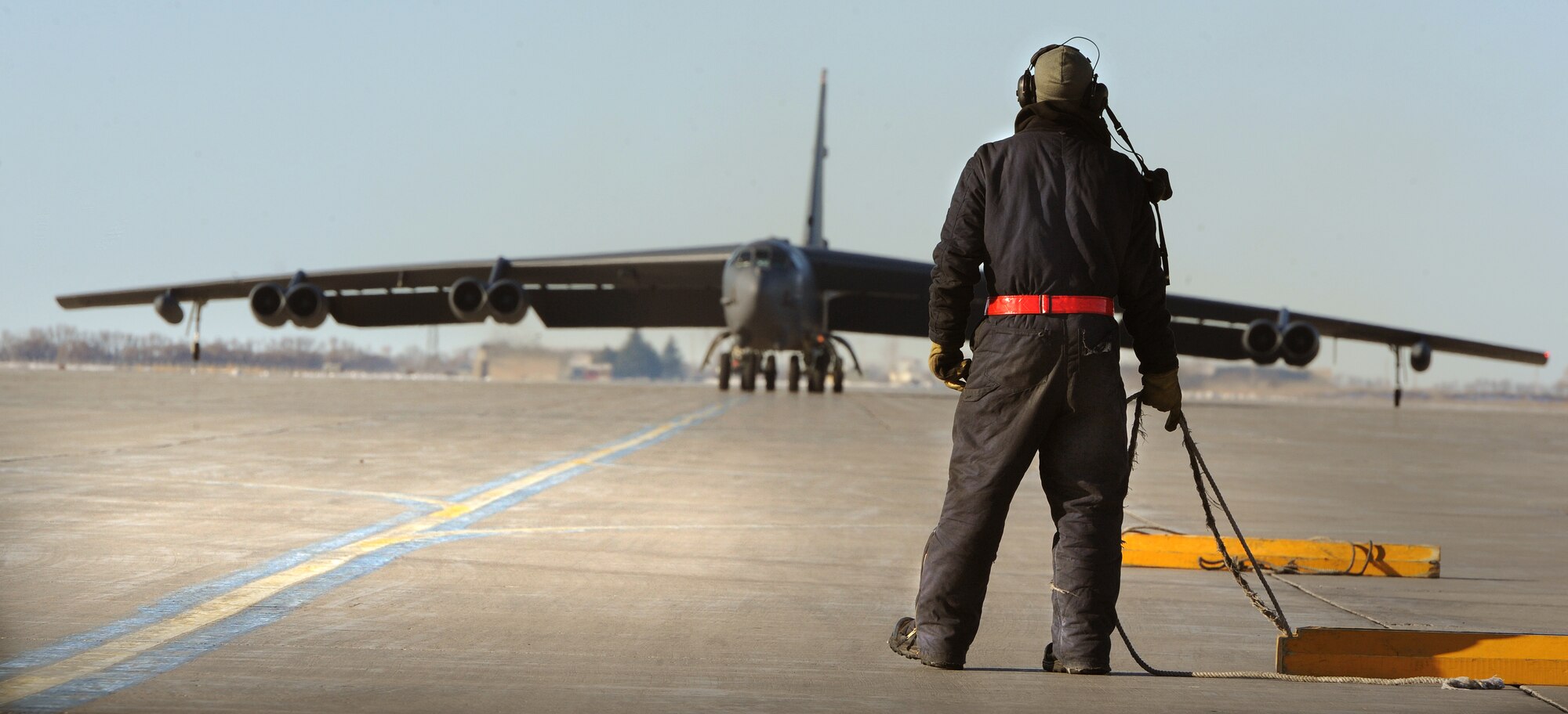 MINOT AIR FORCE BASE, N.D. – An Airman from the 5th Aircraft Maintenance Squadron pulls a set of wheel chocks during a “fini-flight” for Col. James Dawkins Jr., 5th Bomb Wing commander, here, Jan. 7. It is Air Force tradition to have family, friends and Airmen from the wing toast the departing aircrew member and hose them down with water as they debark the aircraft. (U.S. Air Force photo/Senior Airman Brittany Y. Auld)