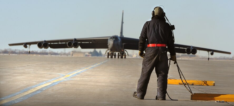 MINOT AIR FORCE BASE, N.D. – An Airman from the 5th Aircraft Maintenance Squadron pulls a set of wheel chocks during a “fini-flight” for Col. James Dawkins Jr., 5th Bomb Wing commander, here, Jan. 7. It is Air Force tradition to have family, friends and Airmen from the wing toast the departing aircrew member and hose them down with water as they debark the aircraft. (U.S. Air Force photo/Senior Airman Brittany Y. Auld)
