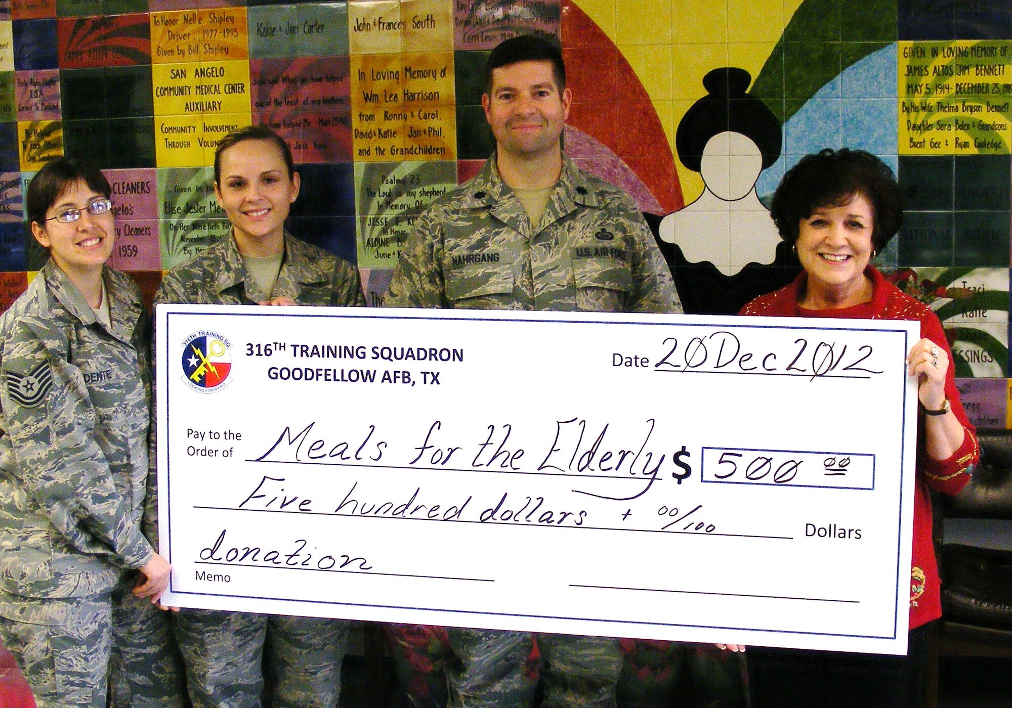GOODFELLOW AIR FORCE BASE, Texas - TSgt Tabitha Redente and TSgt Mari Ann Isom, 316th Training Squadron, and Lt. Col. Scott Nahrgang, 316th TRS commander, present a check to Mrs. Charlyn Ocker, Meals for the Elderly President and CEO, at the Meals for the Elderly facility in San Angelo, Texas, Dec. 20, 2012. Meals for the Elderly is a private, non-profit charitable organization devoted to serving
the homebound elderly of San Angelo and surrounding areas with one hot, nutritious, home-delivered meal each weekday, while also ensuring their individual well-being through personal contact.  (Courtesy photo)
