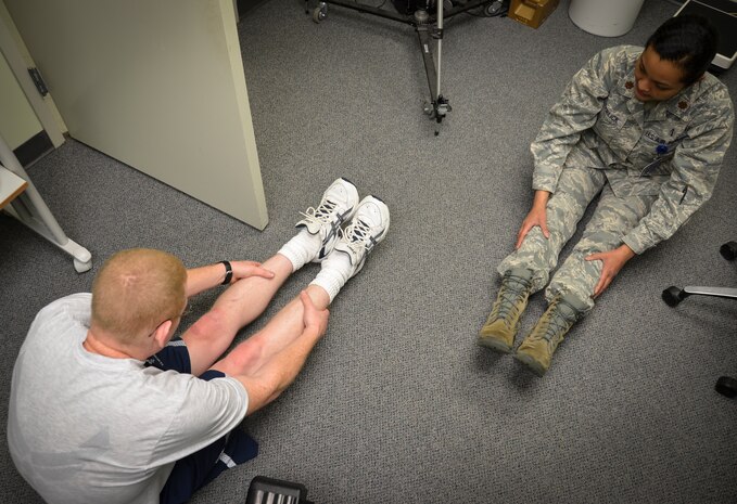 (Right) Maj. Lee Warlick, 628th Medical Operations Squadron Physical Therapy flight commander, shows stretching exercises to Staff Sgt. Christopher Hammond, 437th Aircraft Maintenance Squadron crew chief, during an appointment at the Gait Analysis Clinic, Jan. 8, 2013 at Joint Base Charleston – Air Base, S.C. To utilize this service, TRICARE Prime beneficiaries must set-up an appointment through the 628th Medical Group appointment line. (U.S. Air Force photo/Staff Sgt. Anthony Hyatt)