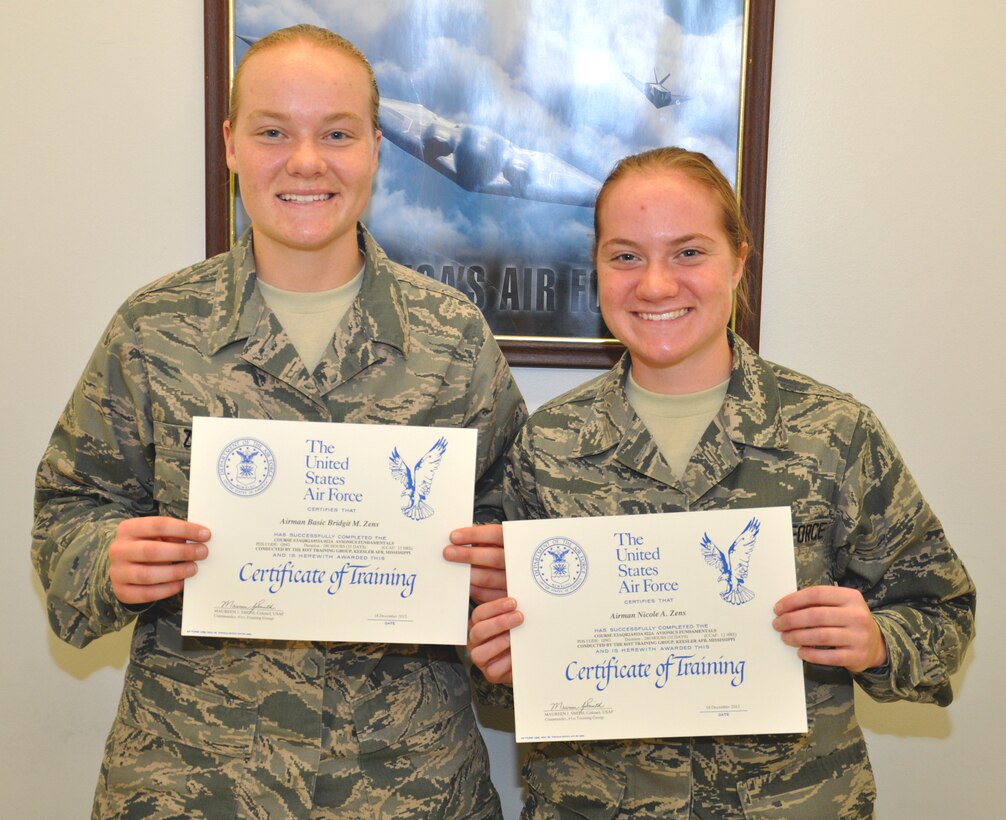 Airman Basic Bridgit Zens and Airman Nicole Zens, 335th Training Squadron students , display their certificates of completion after finishing the avionics fundamental course Dec. 18 at Keesler  Air Force Base, Miss. The two sisters entered basic training together and were in the same class for avionics training here.  (U.S. Air Force photo by Staff Sgt. Eric Summers Jr.)
