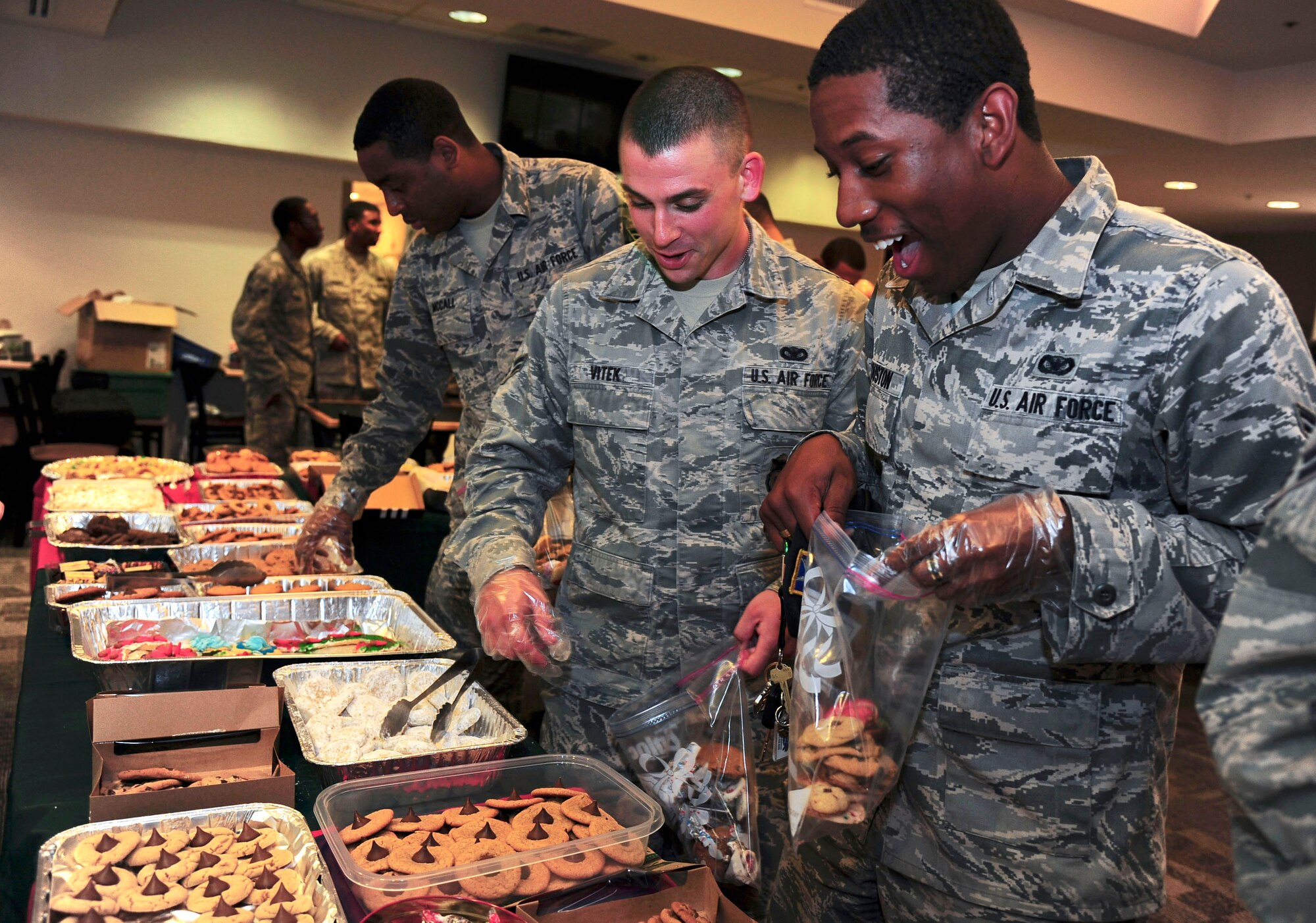 Airman 1st Class Vincent Vitek and Hardrick Houston, 6th Security Force Squadron entry controllers, collect cookies during Operation Cookie Drop at MacDill Air Force Base, Fla., Dec. 12, 2012. The event was a combined effort from the local community and base population to bring homemade cookies to all the single Airmen of MacDill AFB. (U.S. Air Force photo by Staff Sgt Linzi Joseph/Released)
