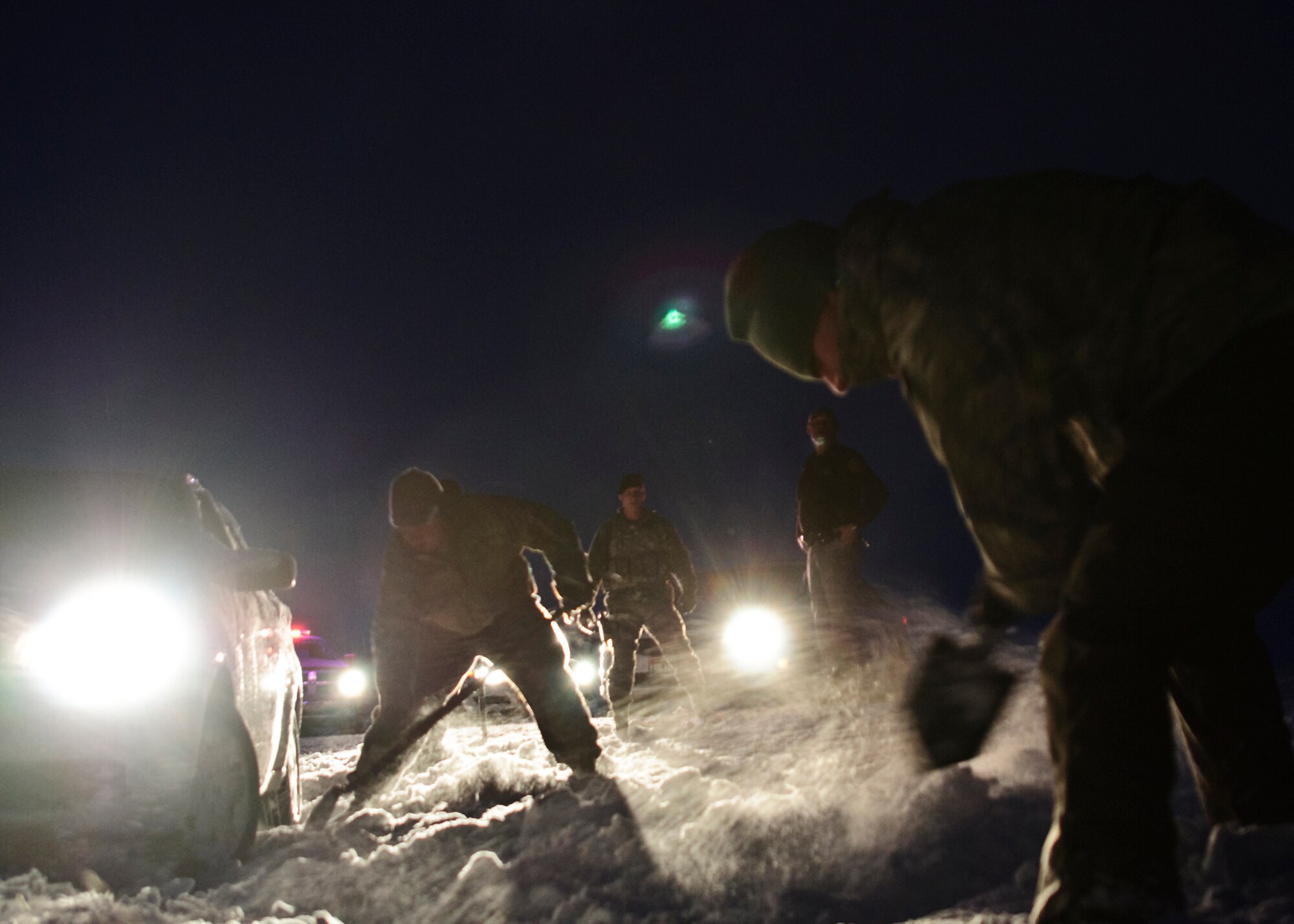 Airmen dig out a stranded driver just driver just outside the Mountain Home Air Force Base main gate, Jan. 10, 2013. Tech. Sgt. Barry Williams, 366th Security Forces Squadron, and three other servicemembers, assisted the stranded driver. (U.S. Air Force photo/Master Sgt. Kevin Wallace/RELEASED)