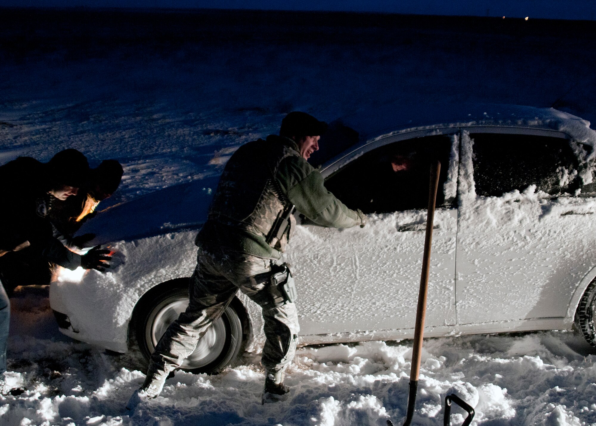 Tech. Sgt. Barry Williams, 366th Security Forces Squadron assists a stranded driver just outside the Mountain Home Air Force Base main gate, Jan. 10, 2013. Williams, along with three other servicemembers stopped to rescue the driver, who'd slipped off the road and was stuck in deep snow. (U.S. Air Force photo/Master Sgt. Kevin Wallace/RELEASED)