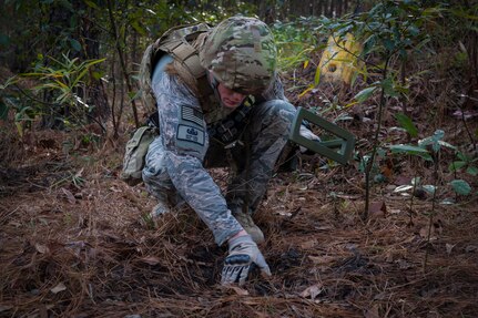 Staff Sgt. Devin Long, 628th Civil Engineer Squadron explosive ordnance disposal technician, searches for a wire used to detonate an improvised explosive device during a routine training exercise Jan. 8, 2013 at Joint Base Charleston - Air Base, S.C. The training prepares EOD members for the tasks involved with finding explosive devices in remote areas during deployments. (U.S. Air Force photo/Airman 1st Class Ashlee Galloway)