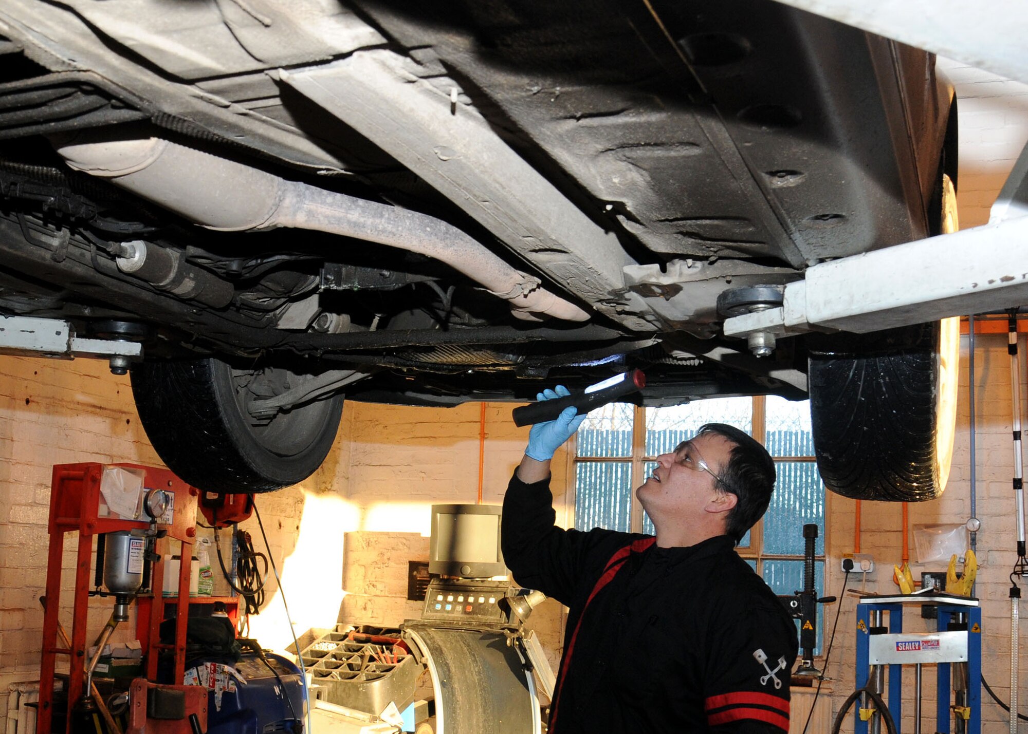 Alex Soto, 100th Force Support Squadron automotive helper from McFarland, Calif., changes the oil for a customer at the auto hobby complex Jan. 9, 2013, at RAF Mildenhall, England. The complex offers a towing service from 8 a.m. to 8 p.m. Monday to Friday. (U.S. Air Force photo by Gina Randall/Released)