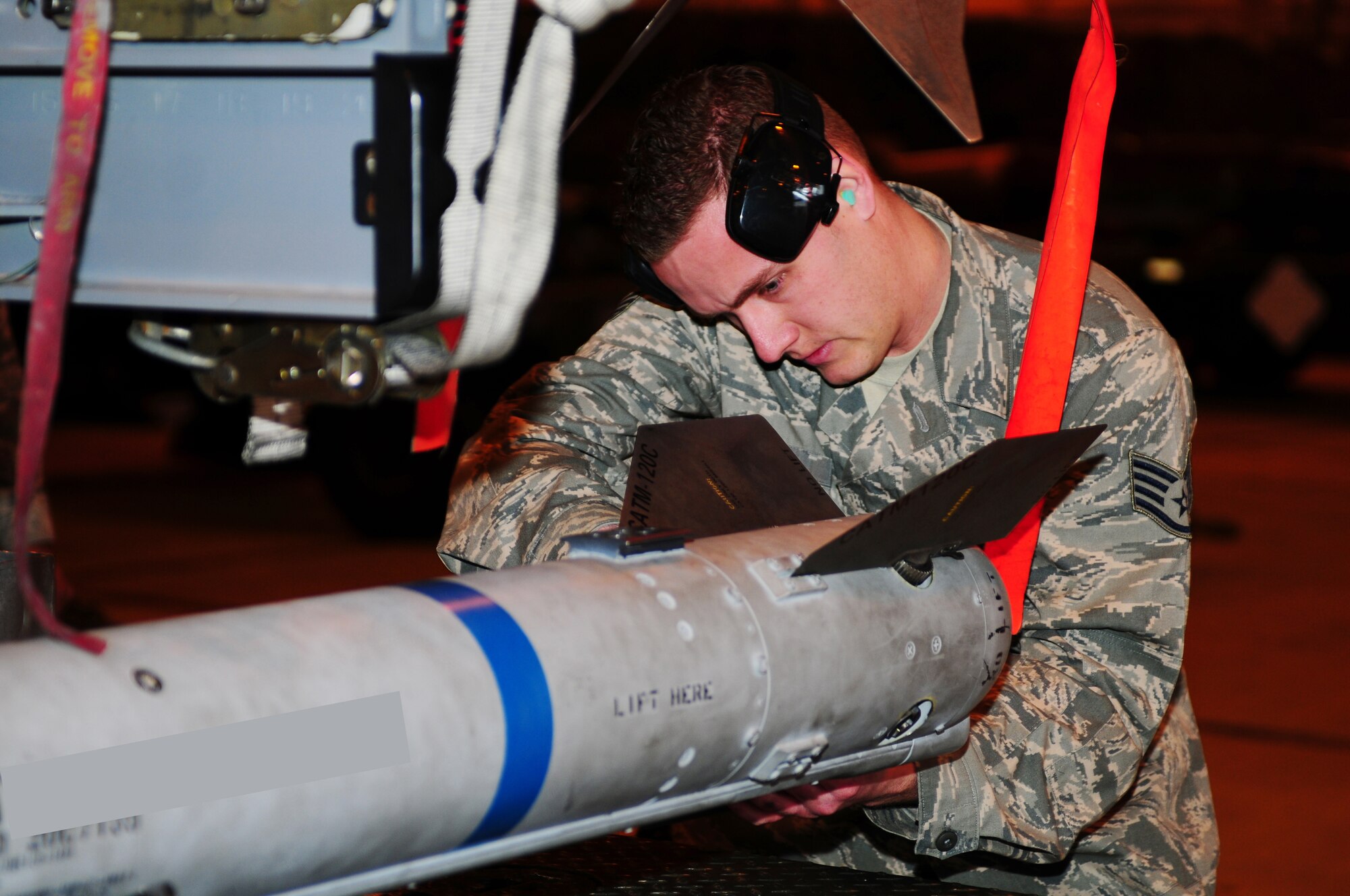ROYAL AIR FORCE LAKENHEATH, England - Staff Sgt. Brian Gates, 48th Munitions Squadron weapons load crew member, prepares an AIM-9 munition for loading onto an F-15C Eagle during the quarterly load crew competition Jan. 7, 2013. The winner is determined by the fastest time loading munitions with the least amount of errors. (U.S. Air Force photo by Airman 1st Class Dana J. Butler)
