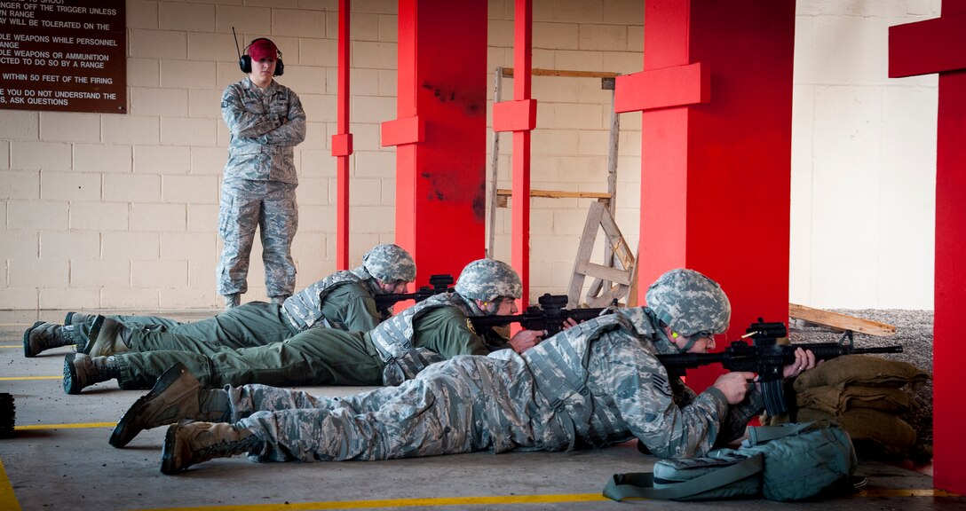 A class of students attending a weapon qualifications course open fire as Staff Sgt. Justin Wood, 47th Security Forces Squadron assistant NCO in charge of combat arms, observes at the firing range on Laughlin Air Force Base, Texas, Jan. 8, 2013. Laughlin produced more than 2,000 pounds of spent brass last year that when recycled earned the base recycling program $3,100. (U.S. Air Force photo/Airman 1st Class Nathan Maysonet)