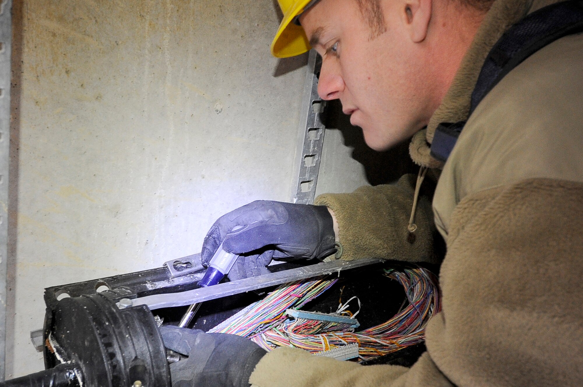 Staff Sgt. Brian Olsen, 455th Expeditionary Communications Squadron, cable and antenna systems technician, ensures communication cables are properly spliced and secured before encasing them to protect them from the elements on Bagram Airfield, Jan. 9, 2013. The communication cables were installed in preparation for base future development. (U.S. Air Force Photo/Master Sgt. Jun Kim)