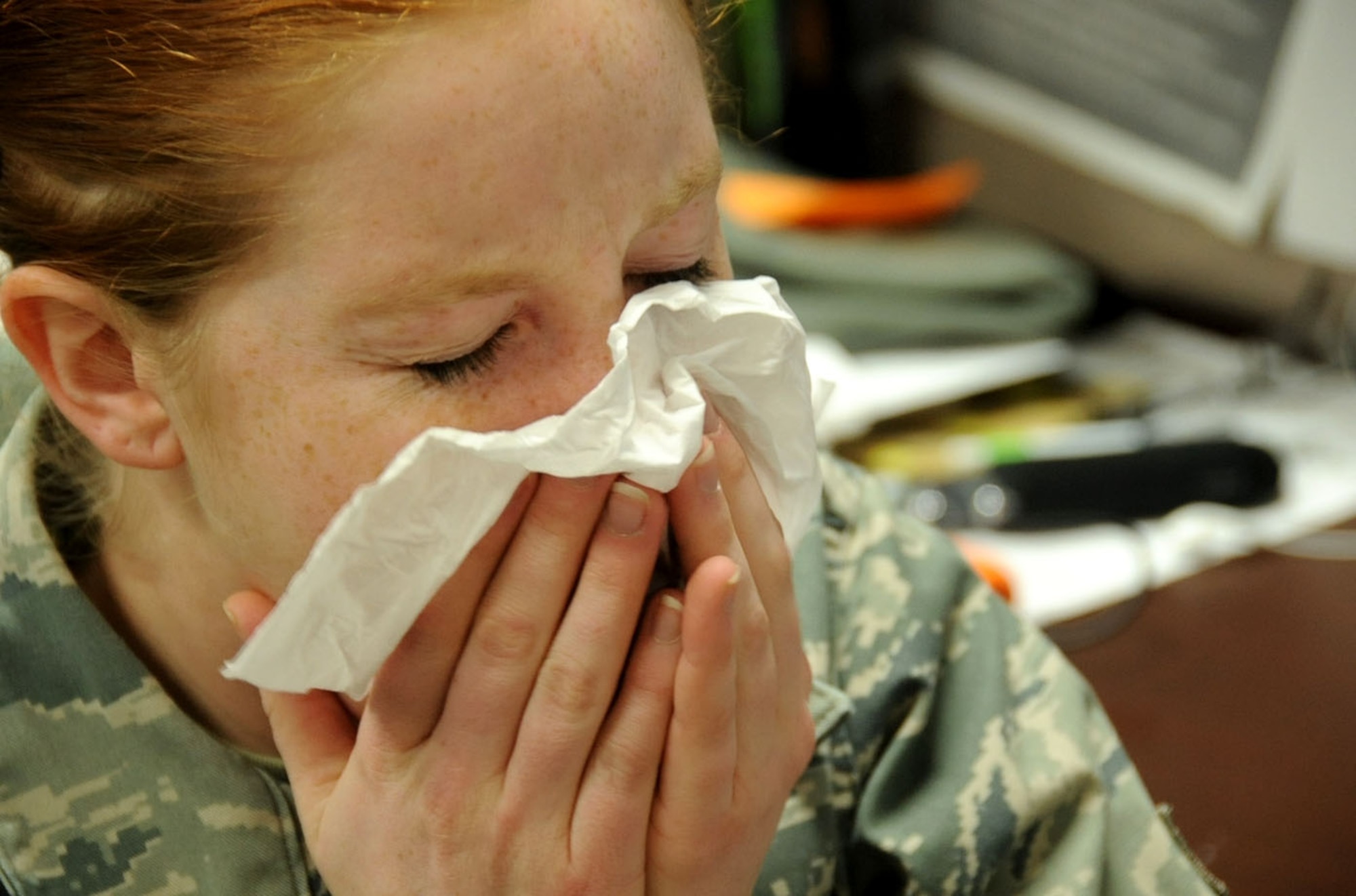 U.S. Air Force Airman 1st Class Kia Atkins, 35th Fighter Wing public affairs photojournalist, sneezes into a tissue while suffering from a cold at Misawa Air Base, Japan, Jan. 9, 2013. The average healthy, individual will suffer a cold at least three times a year or seasonally. According to the Centers for Disease Control and Prevention, the quantity of cold and flu-sufferers increase during October and last till February. For more information on health and wellness or to schedule an appointment, call the 35th Medical Group at 226-6111. (U.S. Air Force photo by Airman 1st Class Kenna Jackson)