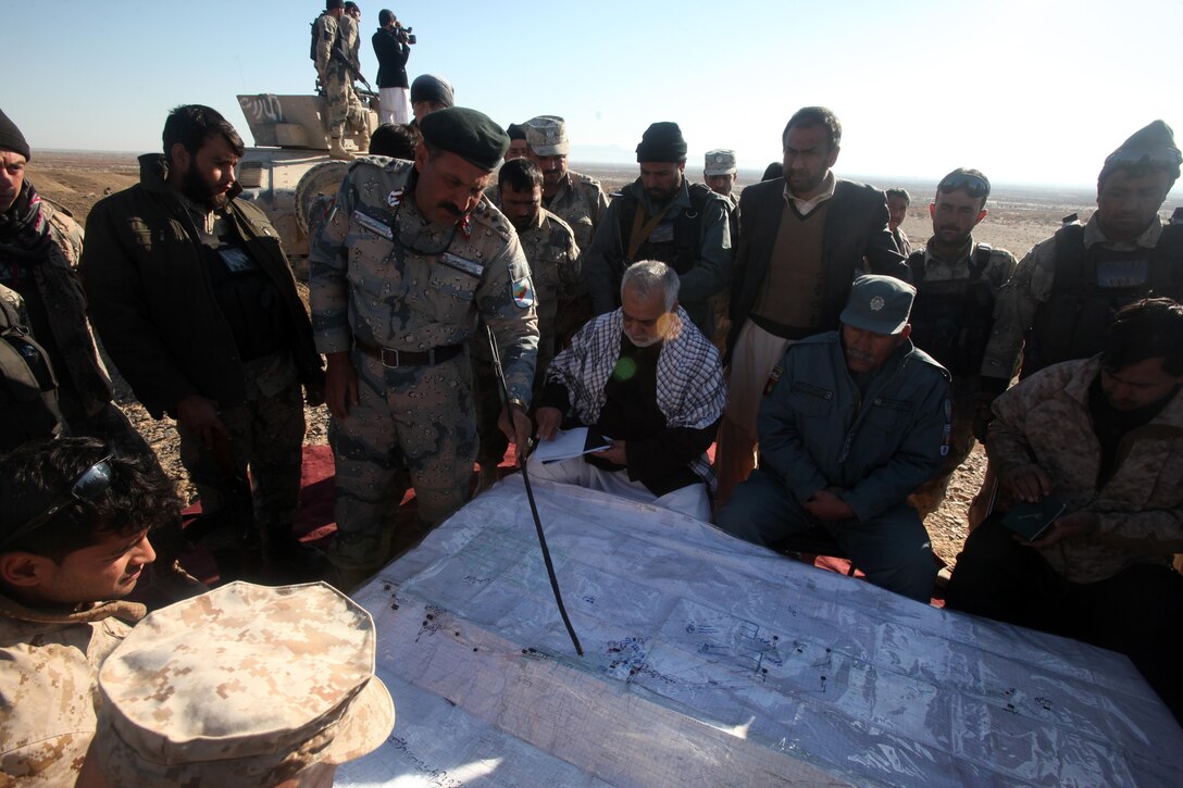Colonel Hamidullah Sadiki, 6th Zone Afghan Border Police chief of staff, gives an overview brief of the clearing operation to Governor Naeem, the governor of Helmand province, Maj. Gen. David Berger, the Task Force Leatherneck commanding general, and coalition and Afghan National Security Forces officials in southern Helmand province, Afghanistan, Dec. 9. The 6th Zone ABP planned, coordinated and has been executing the clearing operation in southern Helmand province for five days.