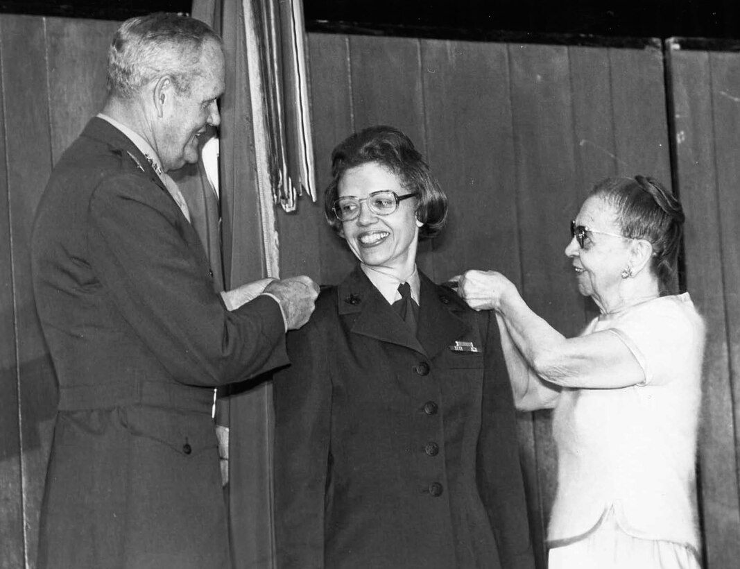 Gen. Louis H. Wilson, commandant of the Marine Corps, and Anne Brewer pin a star to each should during the promotion ceremony for Brig. Gen. Margaret A. Brewer May 11, 1978. She was the first female Marine to be promoted to brigadier general.