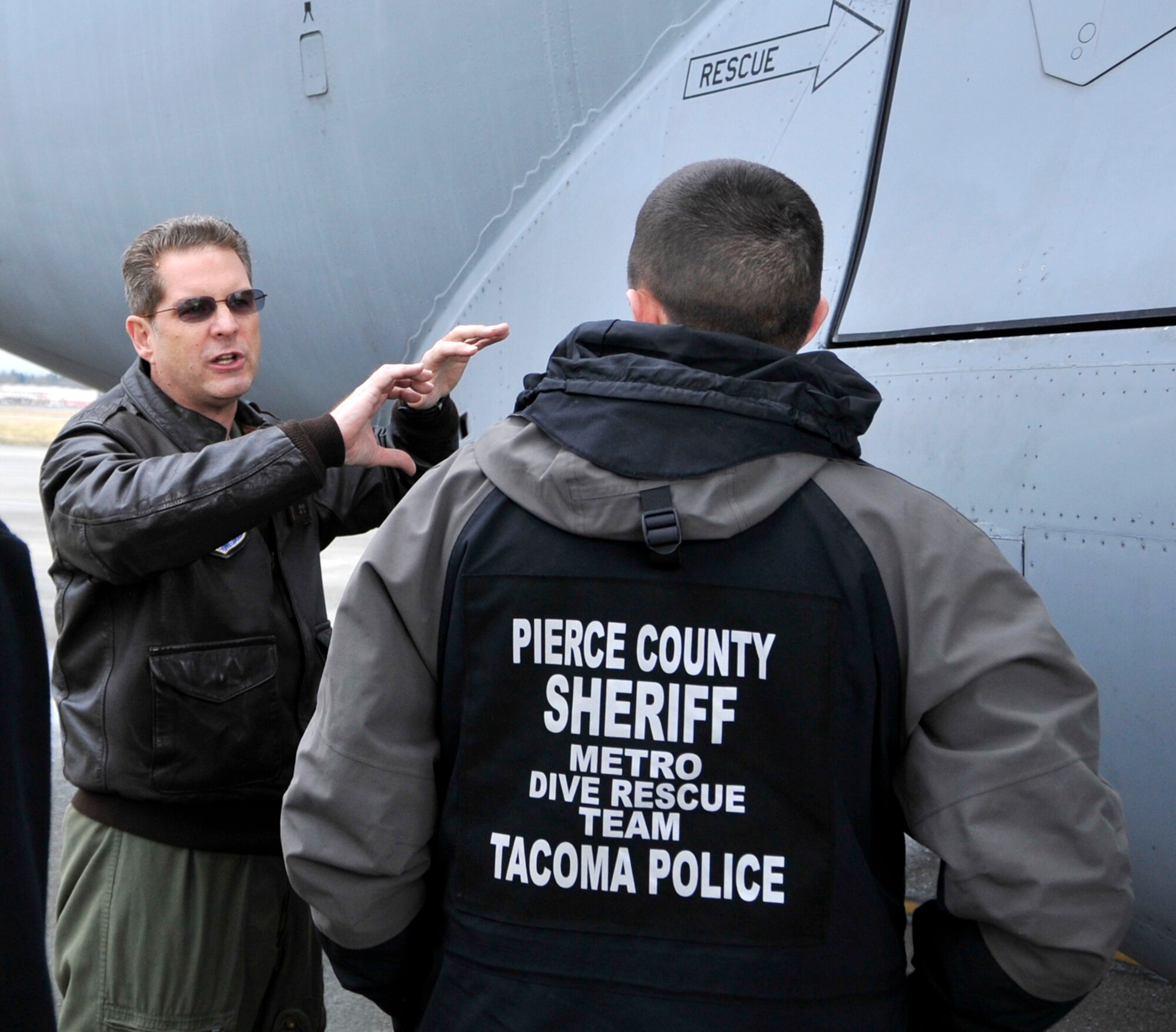 Chief Master Sgt. Jim Masura (left) 446th Operations Group standardization and evaluation loadmaster, provides a member of the Pierce County Metro Dive Team from Tacoma, Wash. with an orientation on the capabilities and various entry and exit points of the C-17 Globemaster III at McChord Field, Wash., Jan. 10, 2013. The dive team visited McChord to receive training on the aircraft, so they would be ready for an incident response in the case of an off-base water landing. (U.S. Air Force photo by Master Sgt. Jake Chappelle)