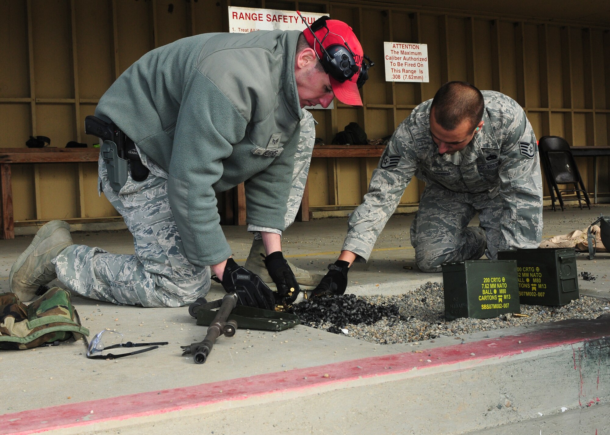 Senior Airman Michael Hughes (left), 9th Security Forces Squadron combat arms instructor, and Staff Sgt. Jay Weber, 9th Munitions Squadron munitions inspector, clean up shells at the heavy weapons range at Beale Air Force Base, Calif., Jan. 11, 2013. Weber fired the M-240B light machine gun during heavy weapons training. (U.S. Air Force photo by Senior Airman Allen Pollard/Released)