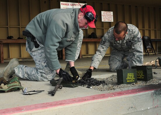 Senior Airman Michael Hughes (left), 9th Security Forces Squadron combat arms instructor, and Staff Sgt. Jay Weber, 9th Munitions Squadron munitions inspector, clean up shells at the heavy weapons range at Beale Air Force Base, Calif., Jan. 11, 2013. Weber fired the M-240B light machine gun during heavy weapons training. (U.S. Air Force photo by Senior Airman Allen Pollard/Released)