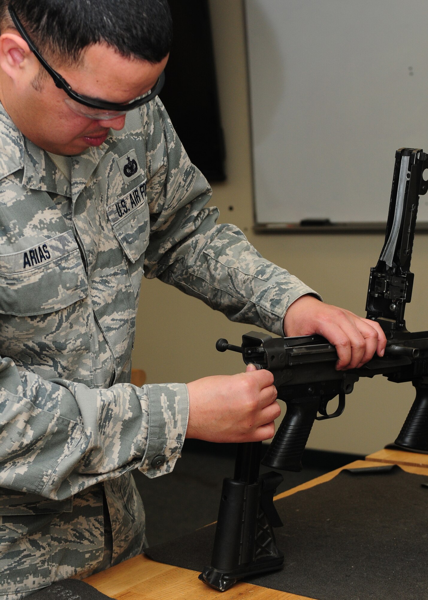 Tech. Sgt. Jesus Arias, 9th Security Forces Squadron NCO in charge of combat arms, breaks down and inspects a M-249 light machine gun at the combat arms facility on Beale Air Force Base, Calif., Jan. 10, 2013. The combat arms instructors are in charge of training and qualifying Team Beale on firing weapons. (U.S. Air Force photo by Senior Airman Allen Pollard/Released)