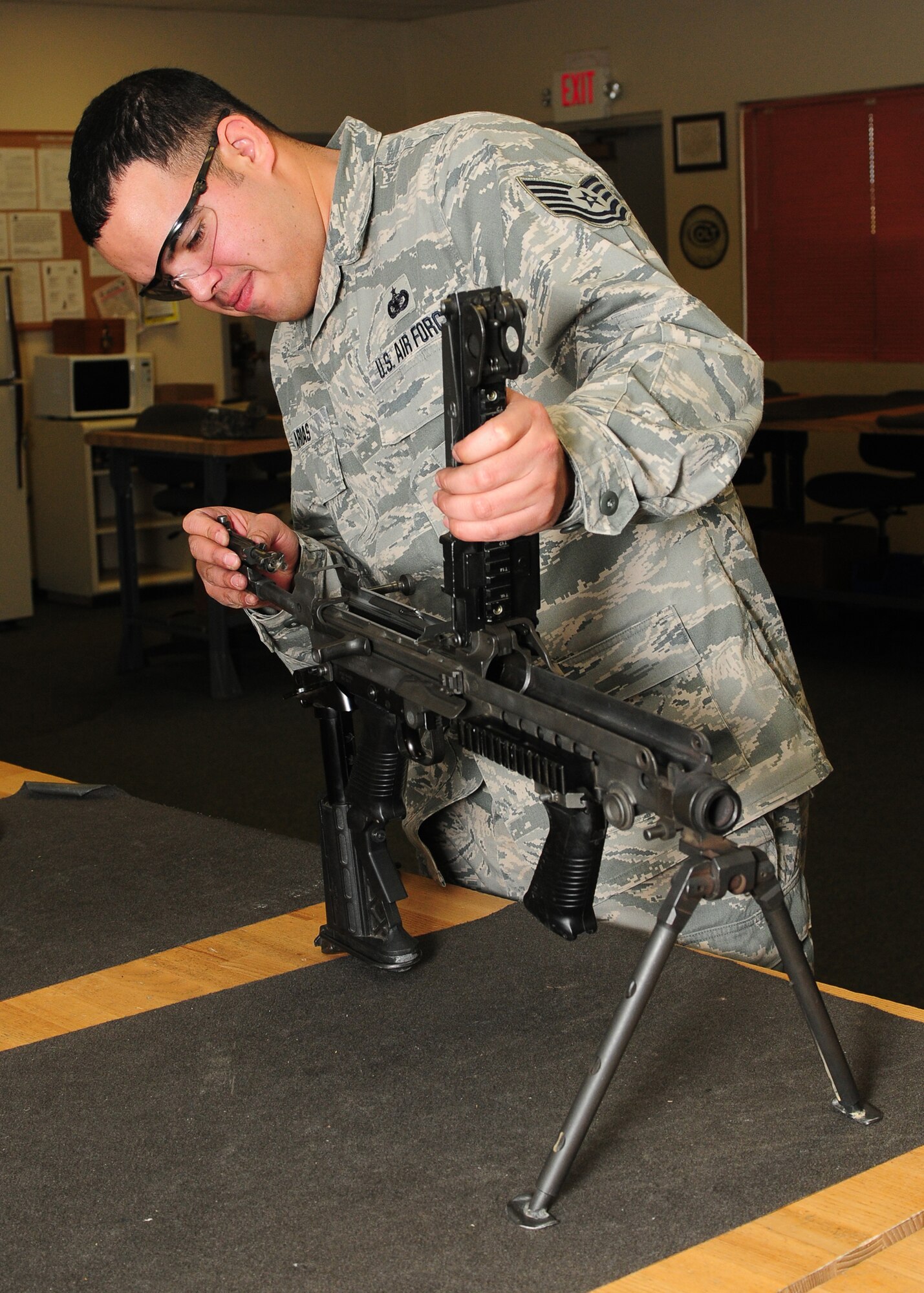 Tech. Sgt. Jesus Arias, 9th Security Forces Squadron NCO in charge of combat arms, breaks down and inspects a M-249 light machine gun at the combat arms facility on Beale Air Force Base, Calif., Jan. 10, 2013. Arias and his team inspect and clean each weapon to ensure they are serviceable for students qualifying on the firing range. (U.S. Air Force photo by Senior Airman Allen Pollard/Released)