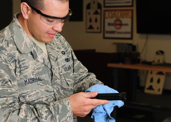 Staff Sgt. Angel Madrigal, 9th Security Forces Squadron combat arms instructor, breaks down and cleans a M-9 Berretta hand gun at the combat arms facility on Beale Air Force Base, Calif., Jan. 10, 2013. The combat arms instructors are in charge of making sure each weapon is clean and serviceable. (U.S. Air Force photo by Senior Airman Allen Pollard/Released)