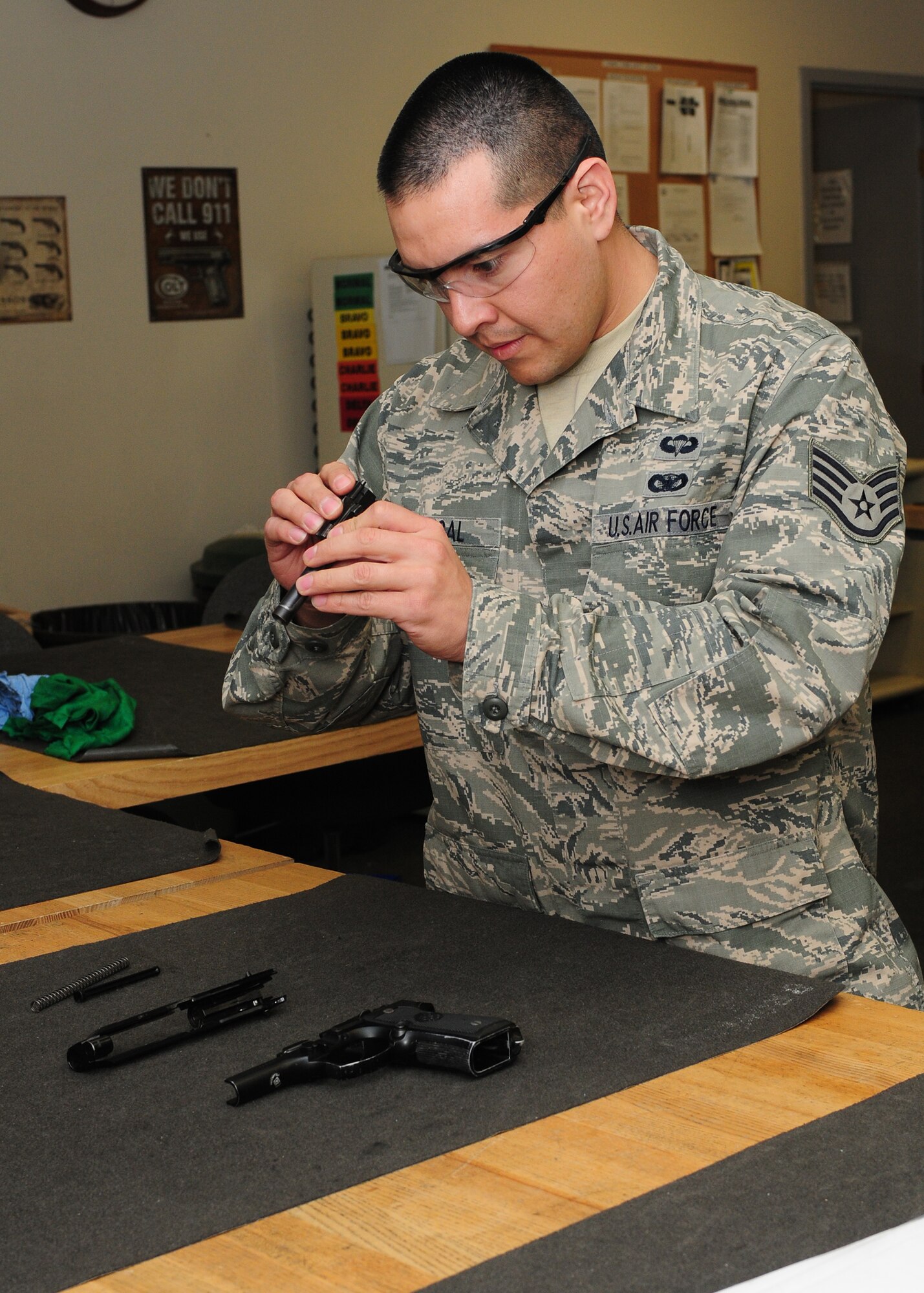 Staff Sgt. Angel Madrigal, 9th Security Forces Squadron combat arms instructor, inspects a M-9 Berretta pistol at the combat arms facility on Beale Air Force Base, Calif., Jan. 10, 2013. The combat arms instructors are in charge of inspecting each weapon to ensure they are serviceable. (U.S. Air Force photo by Senior Airman Allen Pollard/Released)
