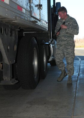 Staff Sgt. Garrett Piel, 9th Security Forces Squadron NCO in charge of the contractor vehicle inspection area, uses a mirror to check for objects attached under vehicles at Beale Air Force Base, Calif., Jan. 10, 2013. Security Forces inspects all contractor vehicles before they can enter the base. (U.S. Air Force photo by Senior Airman Allen Pollard/Released)
