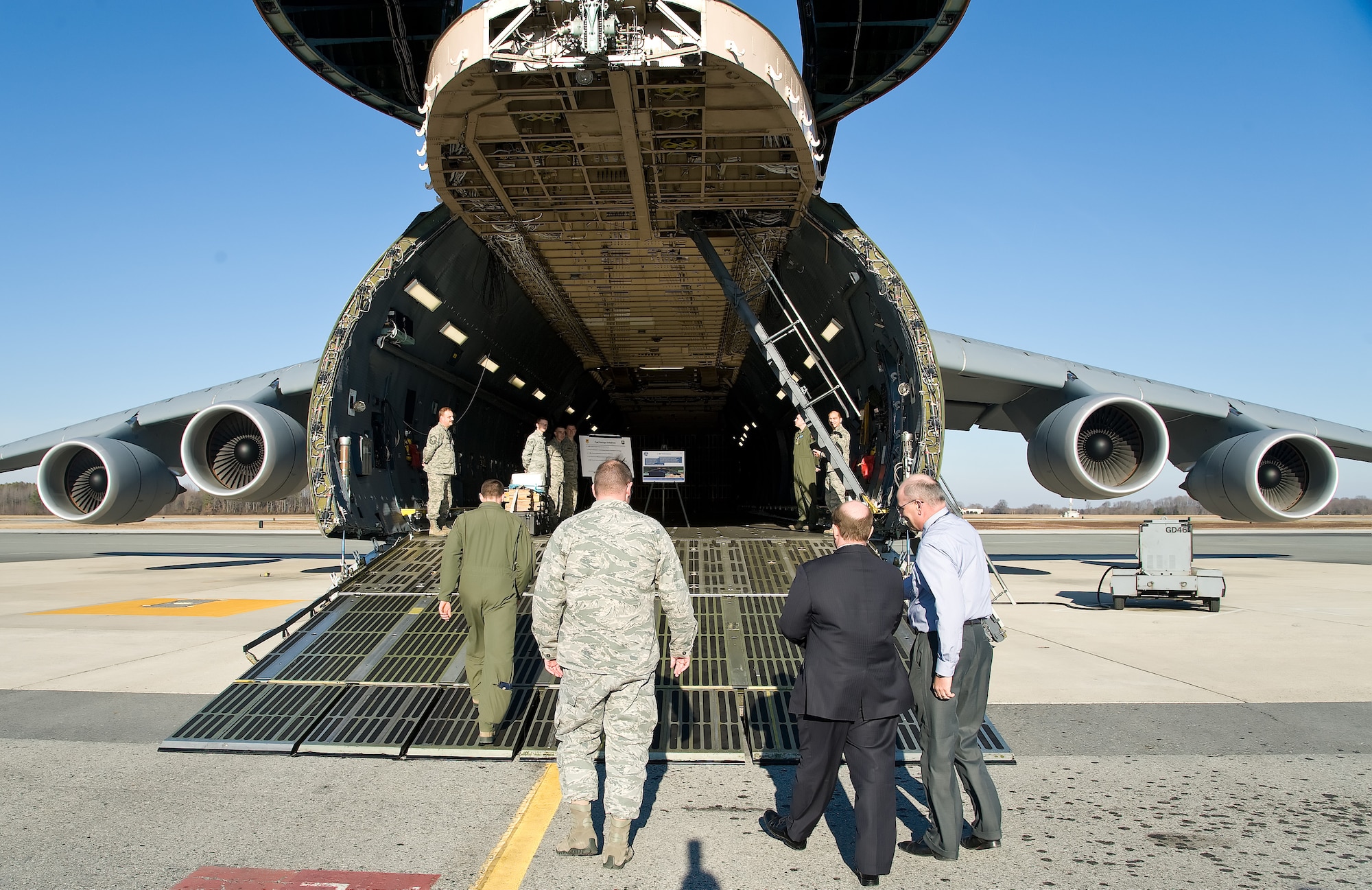 Delaware Senator Christopher Coons, center, walks up the forward ramp of a C-5M Super Galaxy Jan. 10, 2013, at Dover Air Force Base, Del. Coons received a briefing by members of the 436th Aircraft Maintenance Squadron and 436th Operations Group about  C-5M performance and fuel savings initiatives. (U.S. Air Force photo/Roland Balik)