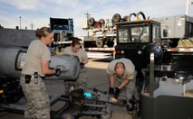 Staff Sgt. Brittany Dorsett and Senior Airman Megan Bright, 2nd Logistics Readiness Squadron shipment and distribution section, assist Staff Sgt. Floyd Hyde, 20th Aircraft Maintenance Squadron, Shaw Air Force Base, S.C., tow an external fuel tank for an F-16 Fighting Falcon on Barksdale Air Force Base, La., Jan. 11. The F-16s are set to arrive Barksdale for Green Flag East, where they undergo training with Soldiers from Fort Polk, La., by rehearsing close-air support operations and procedures. (U.S. Air Force photo/Airman 1st Class Andrew Moua)