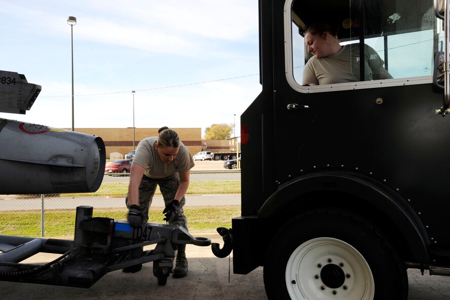 Staff Sgt. Brittany Dorsett and Senior Airman Megan Bright, 2nd Logistics Readiness Squadron shipment and distribution section, prepare to tow an external fuel tank for an F-16 Fighting Falcon in support of exercise Green Flag East on Barksdale Air Force Base, La., Jan. 11. Exercise GFE supports deploying U.S. Air Force and U.S. Army units by providing a means to rehearse close-air support operations and procedures. (U.S. Air Force photo/Airman 1st Class Andrew Moua)